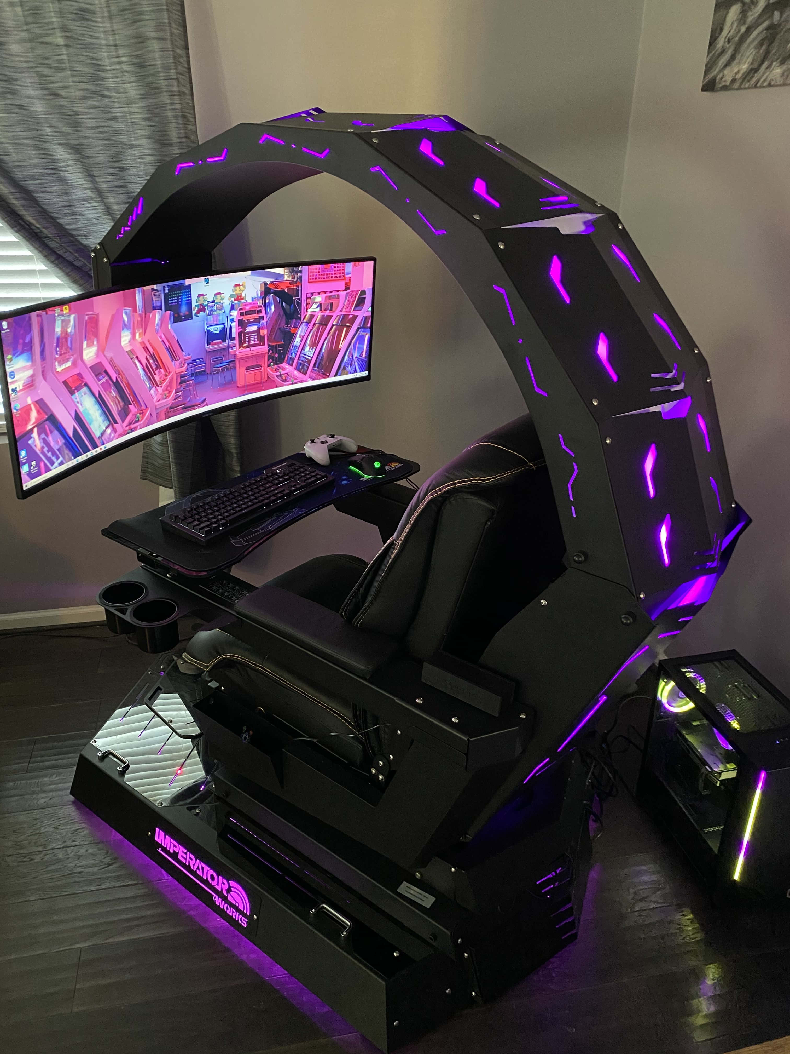 Gaming Chairs 桌布 壁紙 — 一張帶有紫色LED燈的未來感黑色電競椅，在昏暗的房間內拱起於顯示街機遊戲的曲面顯示器之上。