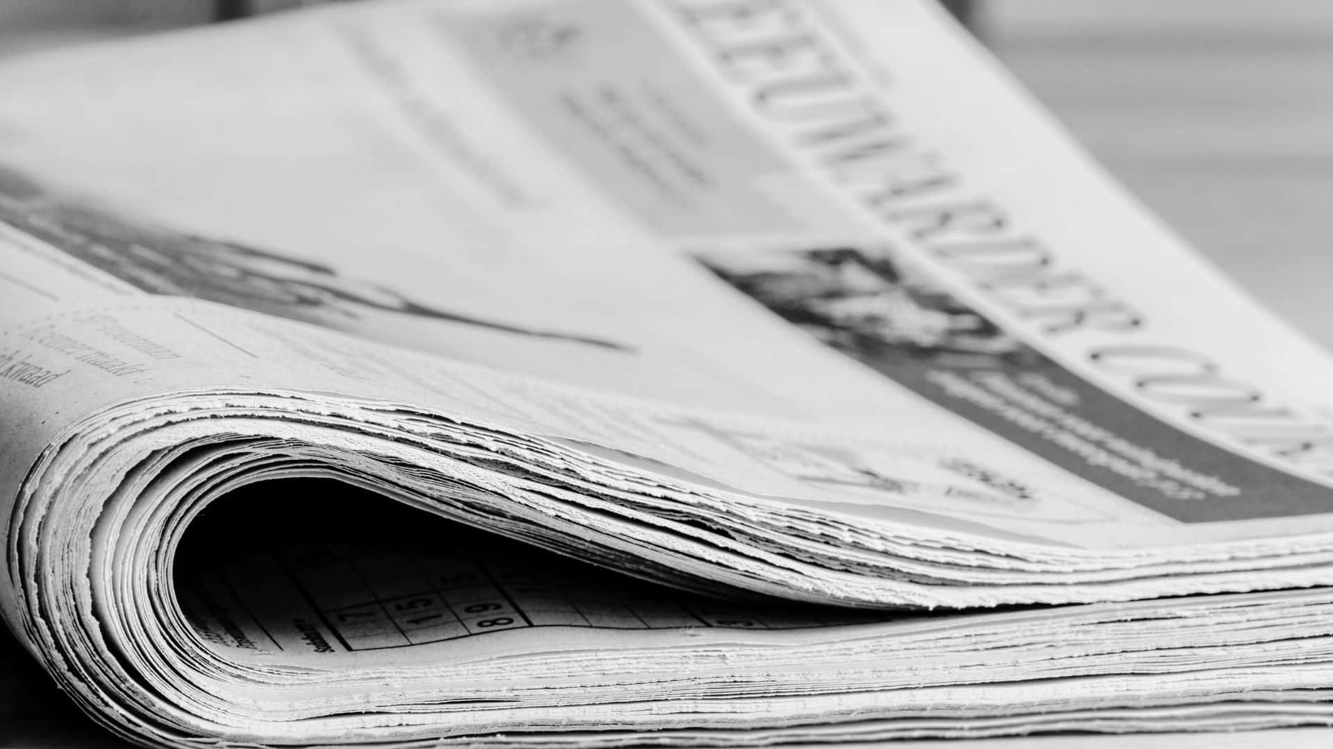 Black And White Newspaper 桌布 壁紙 — 一張摺疊報紙的特寫黑白照片，展現出文字和照片的清晰質感。