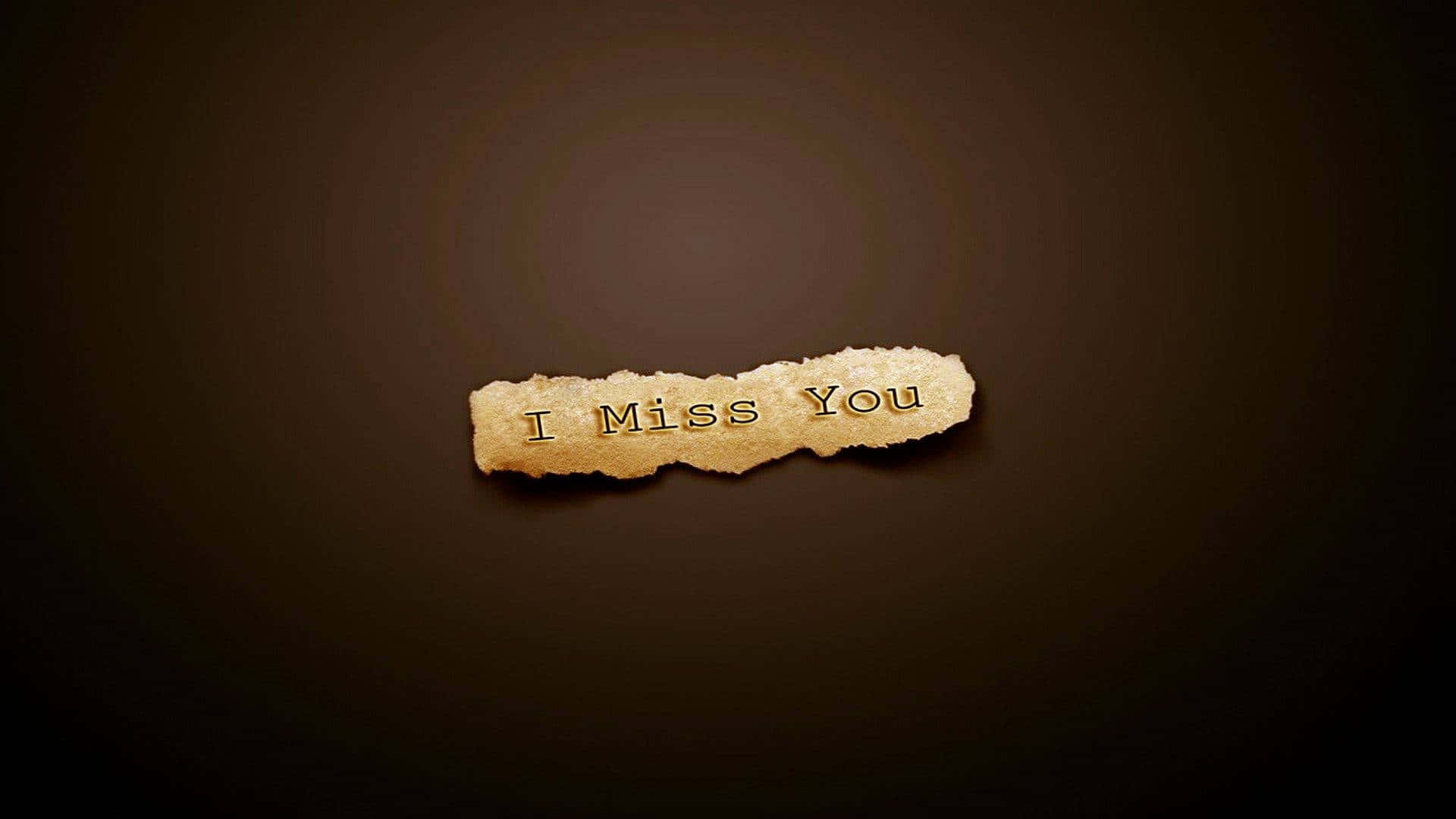 I Miss You 桌布 壁紙 — 一張撕破的紙片，上面有金色字體寫著「I Miss You」，漂浮在深棕色漸變背景上。