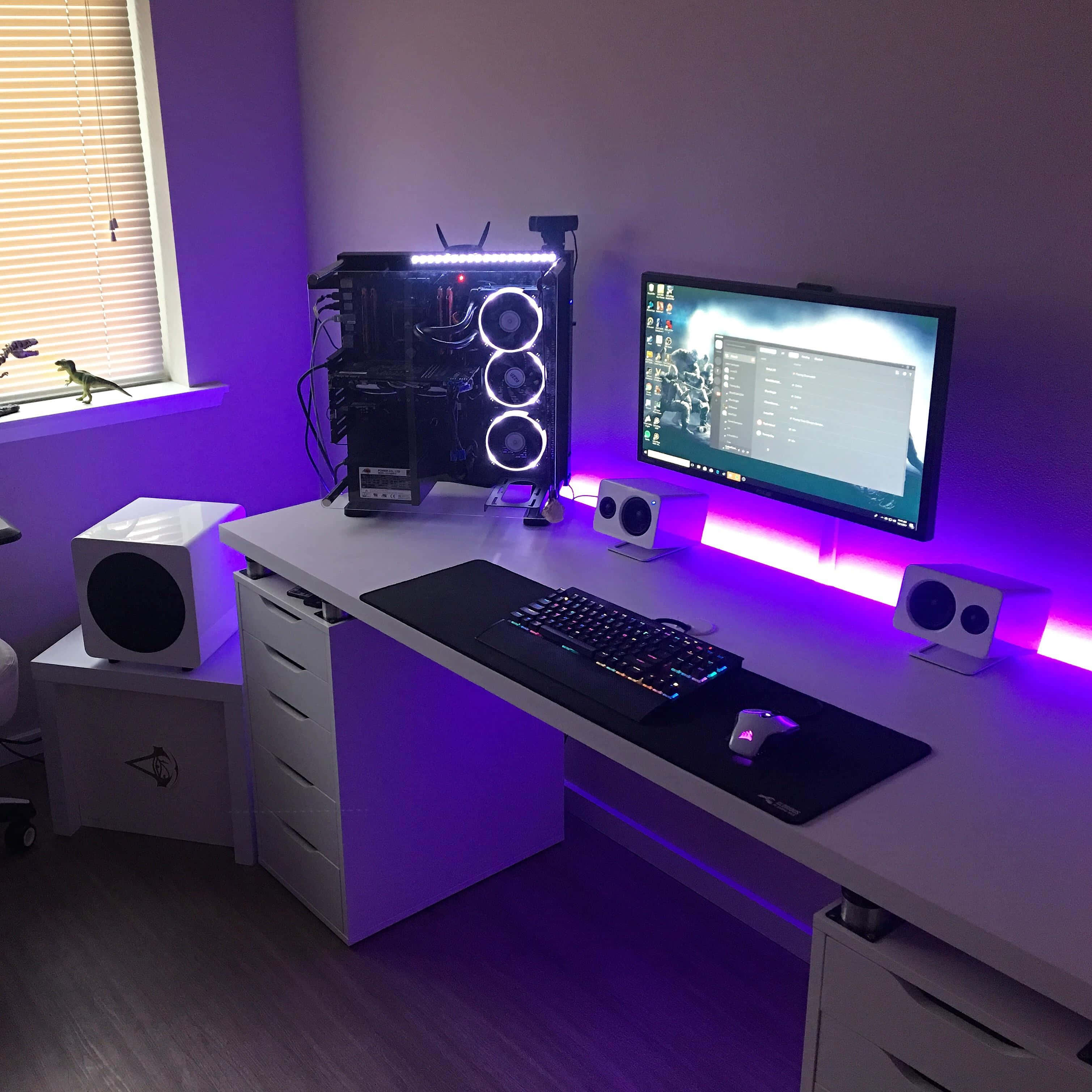 Gaming Pc Setup 桌布 壁紙 — 一張時尚的白色遊戲桌，沐浴在充滿活力的紫色LED燈光中，配備高端PC主機和顯示遊戲的顯示器。