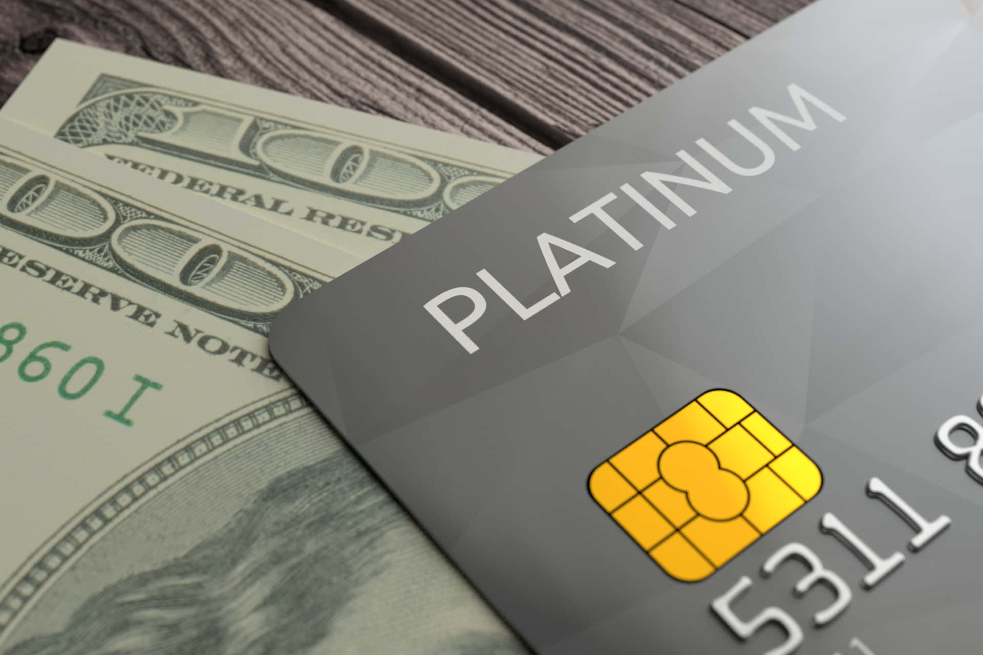 Credit Card 桌布 壁紙 — 一張時尚的鉑金信用卡放在質感木質表面上的清晰美元鈔票上。