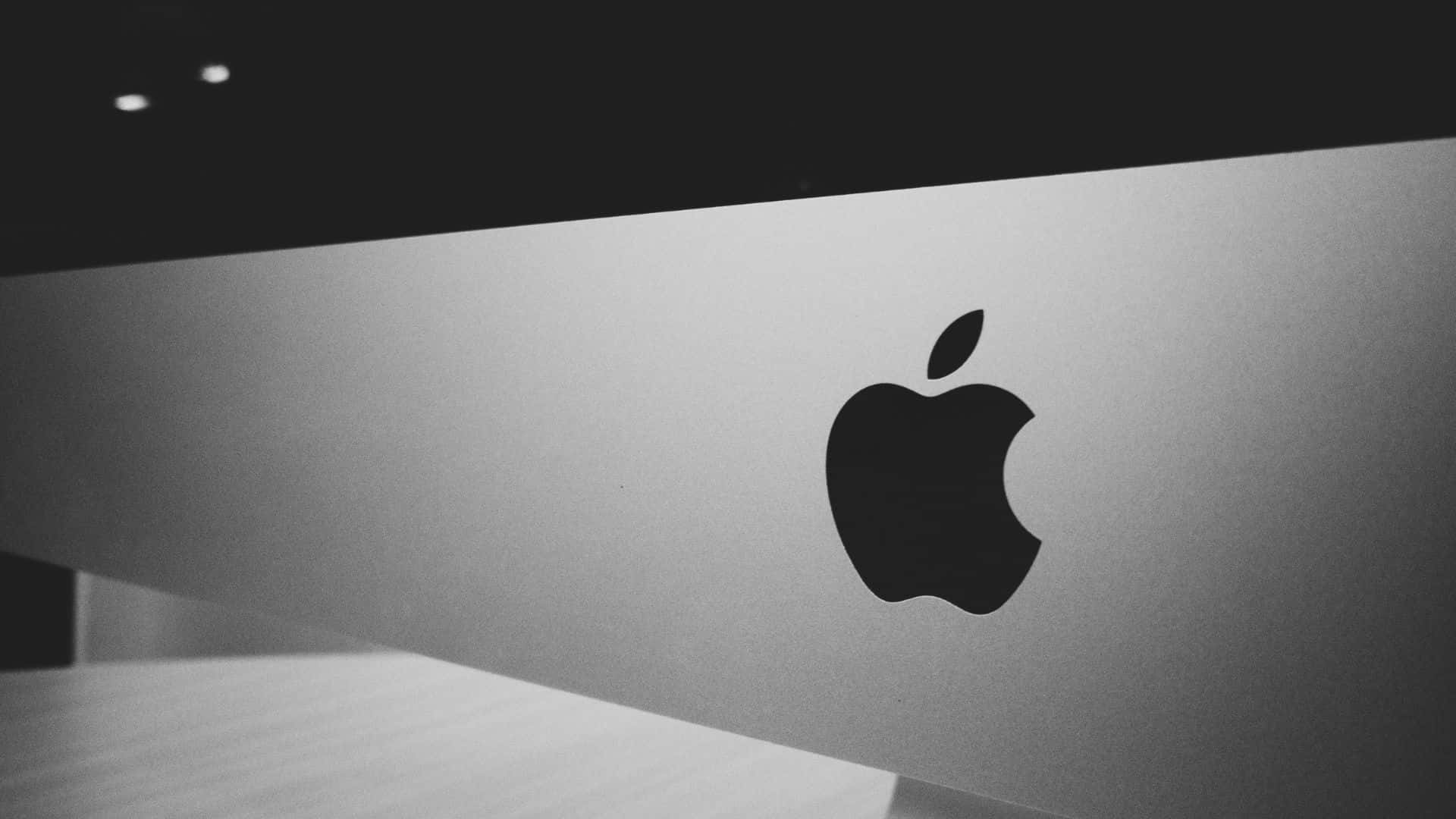 蘋果標誌 桌布 壁紙 — 一張極簡黑白照片，Apple 標誌位於光滑銀色表面上，光線柔和。
