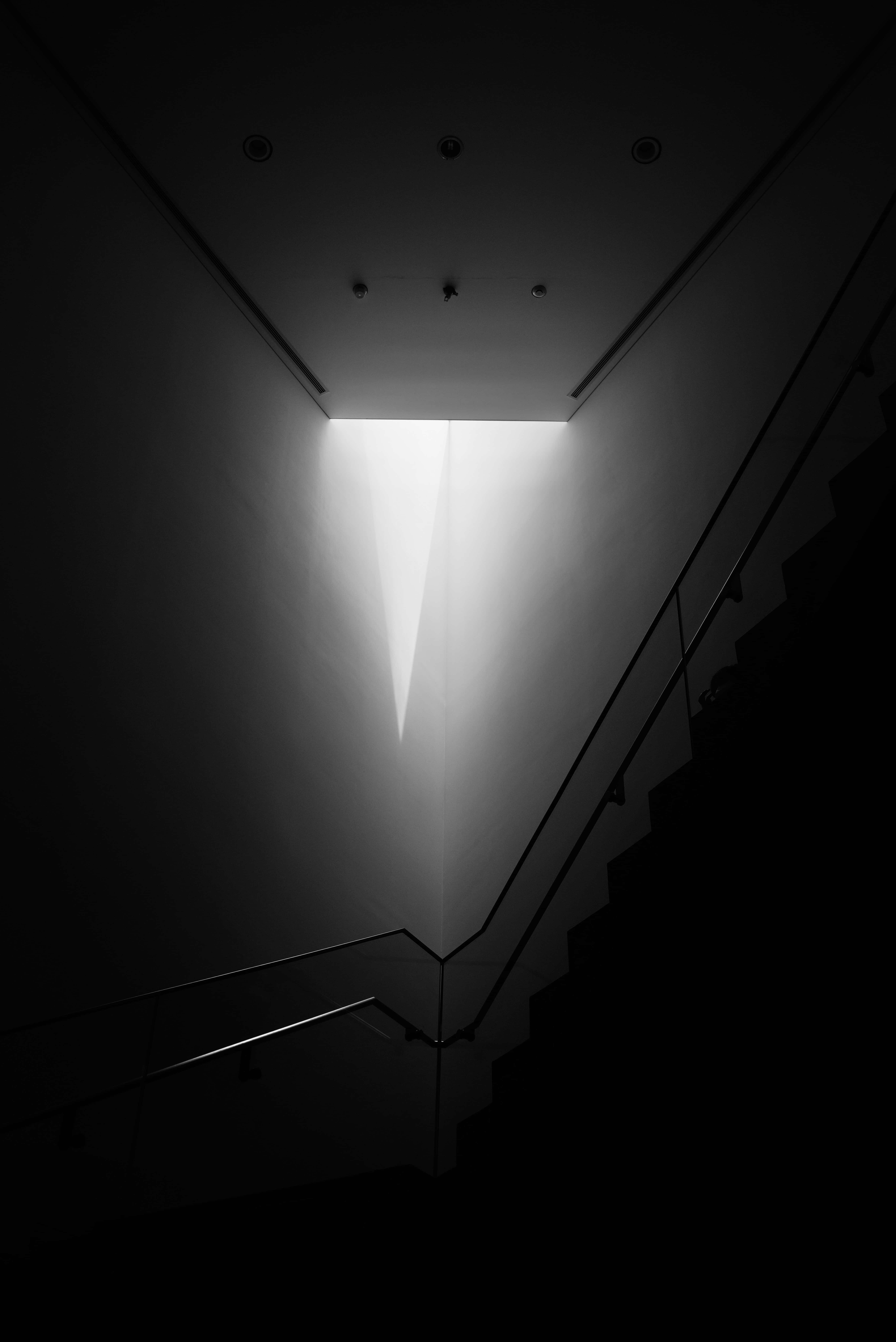 Dark Corner 桌布 壁紙 — 一張清晰的黑白照片，拍攝樓梯向上通往來自上方的一道光芒。