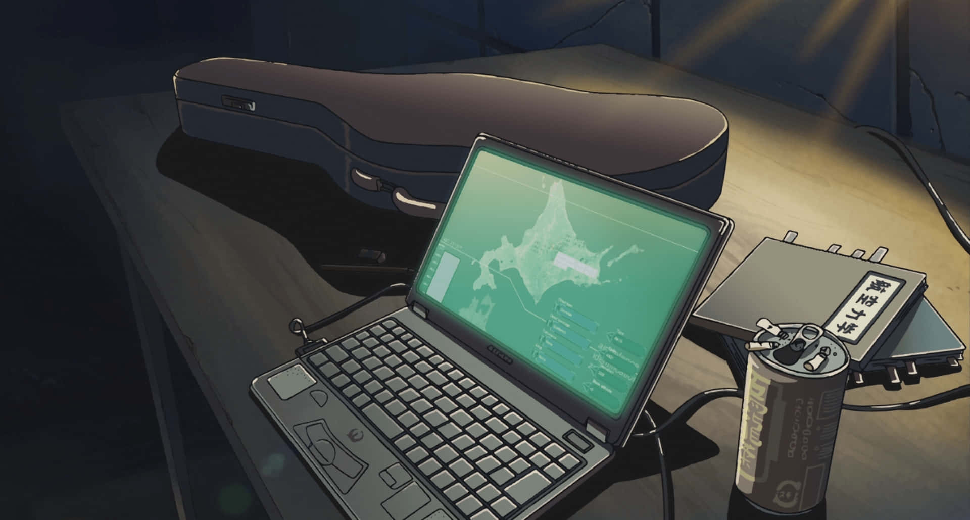 Best Laptop 桌布 壁紙 — 一張燈光昏暗的桌子上放著一部顯示綠色地圖的筆記本電腦，旁邊有一個小提琴盒和電子設備，在溫暖的聚光燈下。