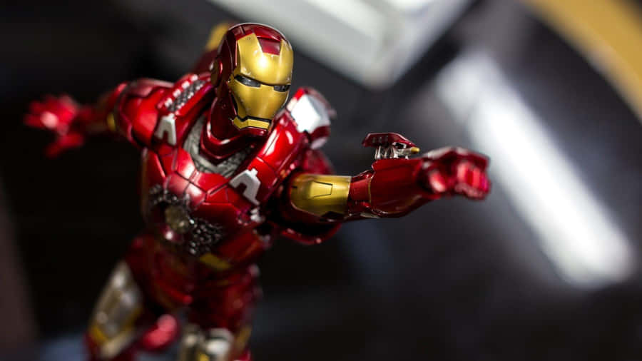Iron Man Action Figures 桌布 壁紙 — 一張特寫照片，展示了一個細節豐富的紅色和金色鐵甲奇俠動作人偶，在模糊的深色背景前動態擺姿勢。