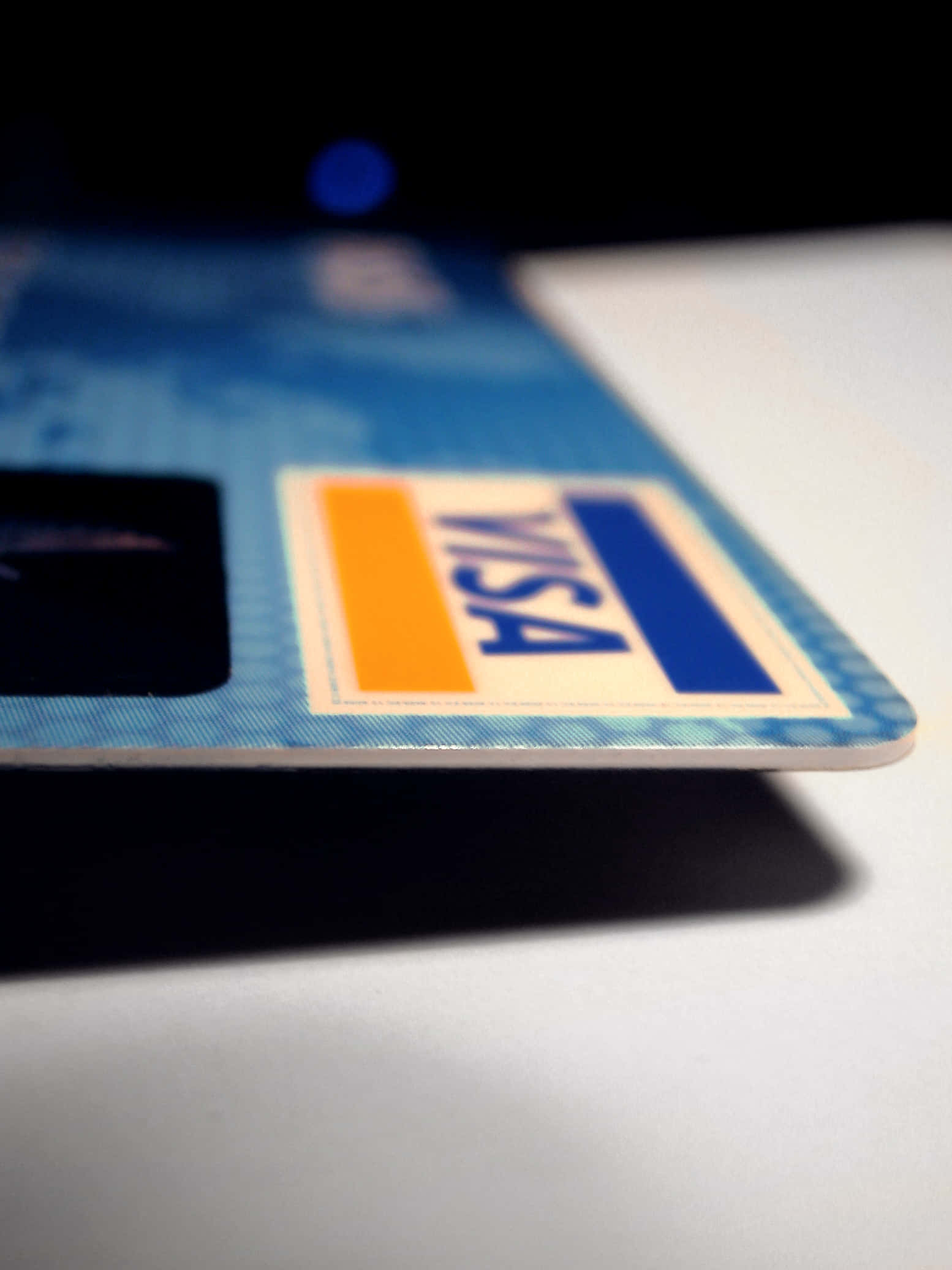 Credit Card 桌布 壁紙 — 一張藍色Visa信用卡傾斜放置在白色表面上的特寫，景深較淺。
