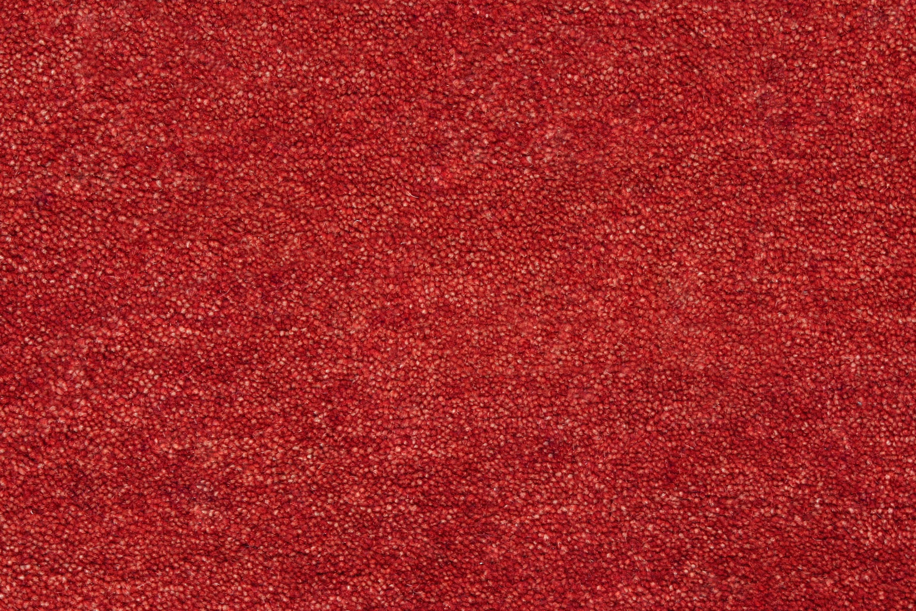Carpet Texture 桌布 壁紙 — 一張豐富紅色紋理布料的近距離特寫，具有均勻的顆粒表面和微妙的顏色變化。