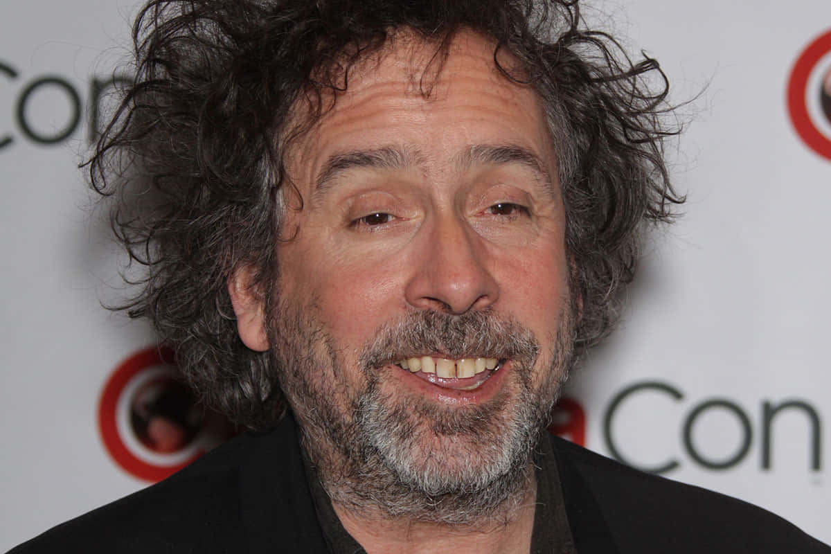 tim burton 桌布 壁紙 — 一張近距離拍攝的照片，一名留著灰色捲髮和鬍鬚的男子在Comic-Con活動中微笑。