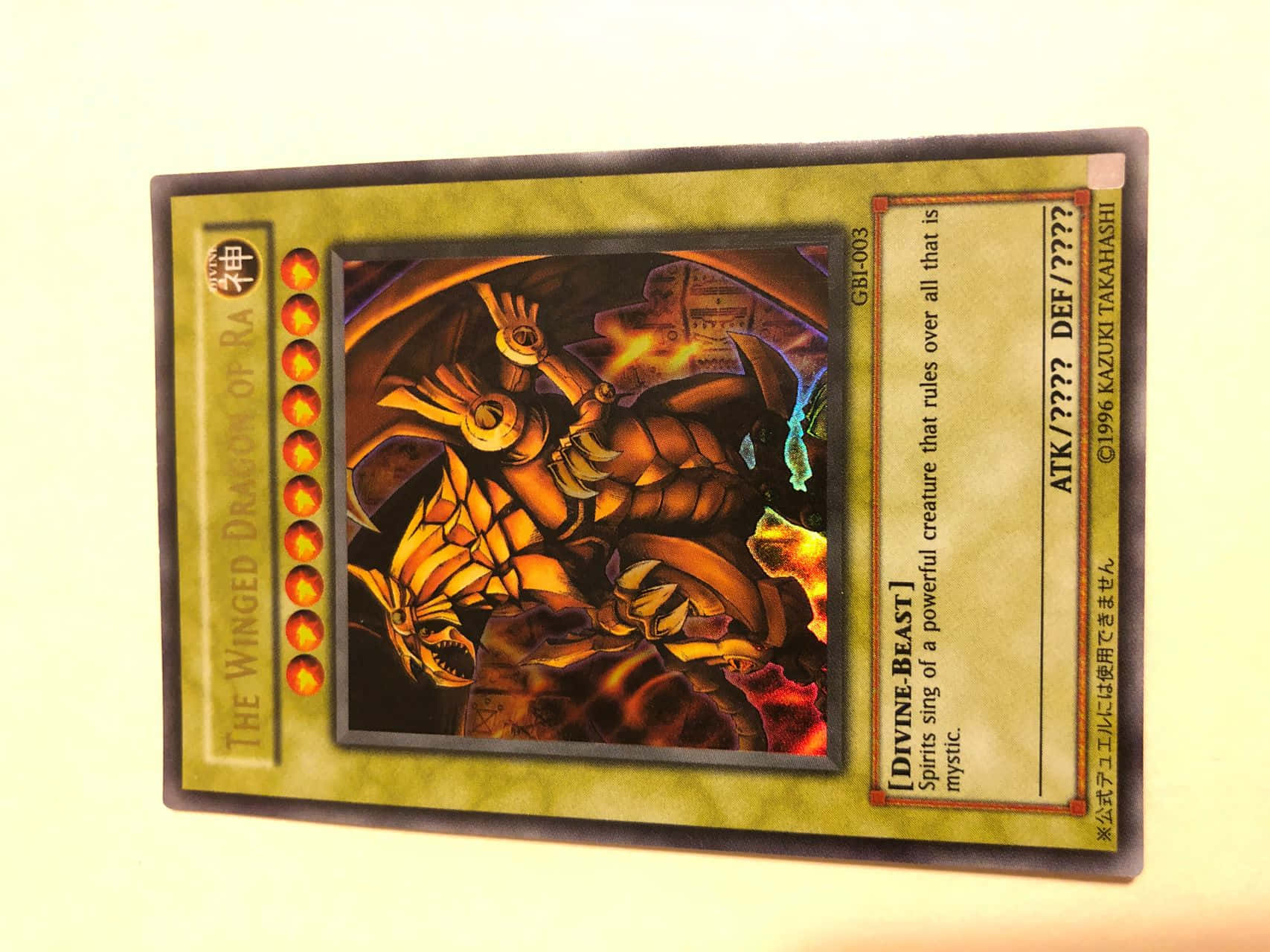 The Winged Dragon Of Ra 桌布 壁紙 — 一張遊戲王集換式卡牌，描繪了拉之翼神龍，擁有火焰般的金色翅膀和一隻發光的眼睛，背景為深色。