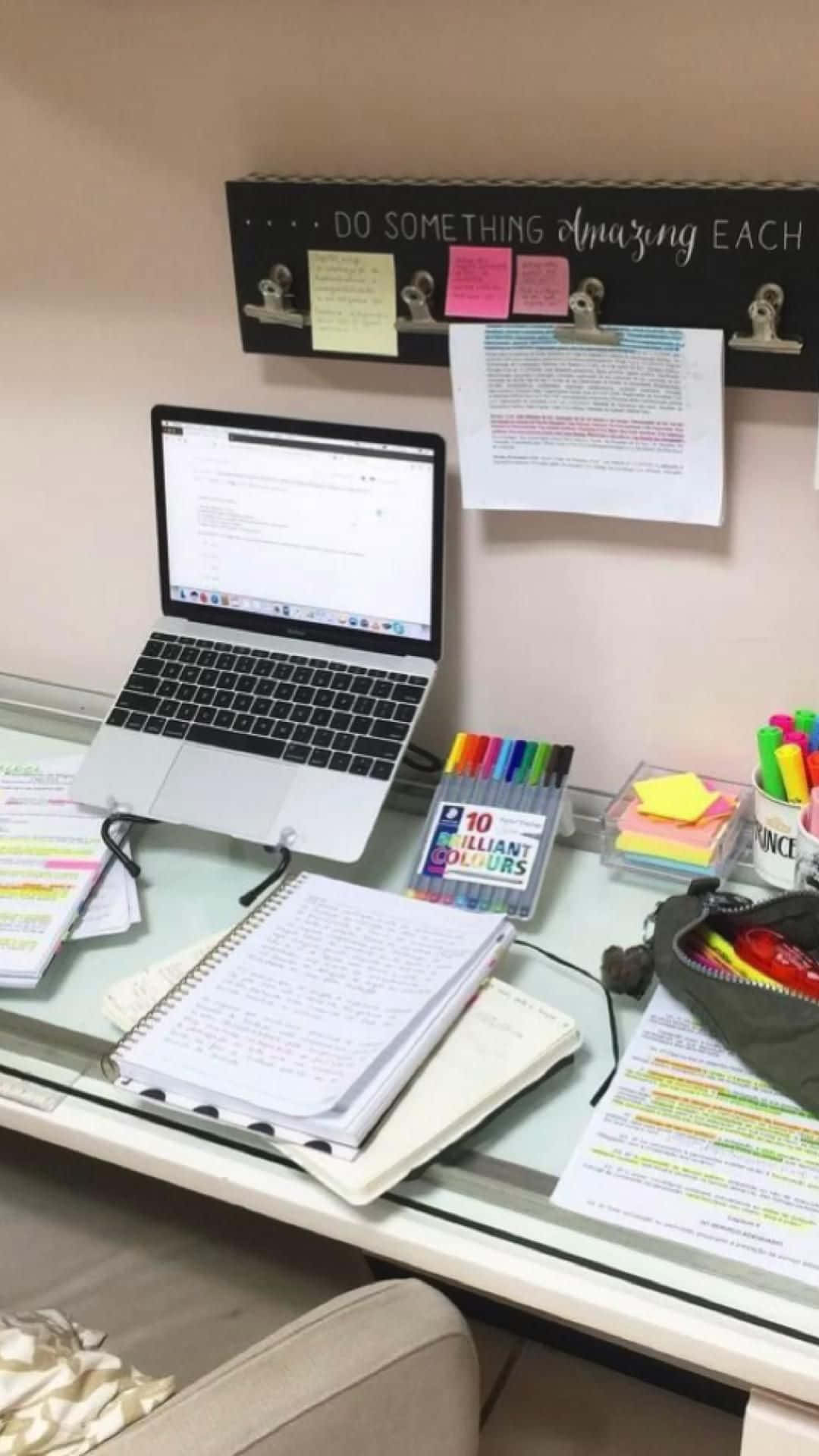 溫習 桌布 壁紙 — 一張雜亂的玻璃桌上放著手提電腦、筆記本和色彩繽紛的文具，上方有一個勵志標語。