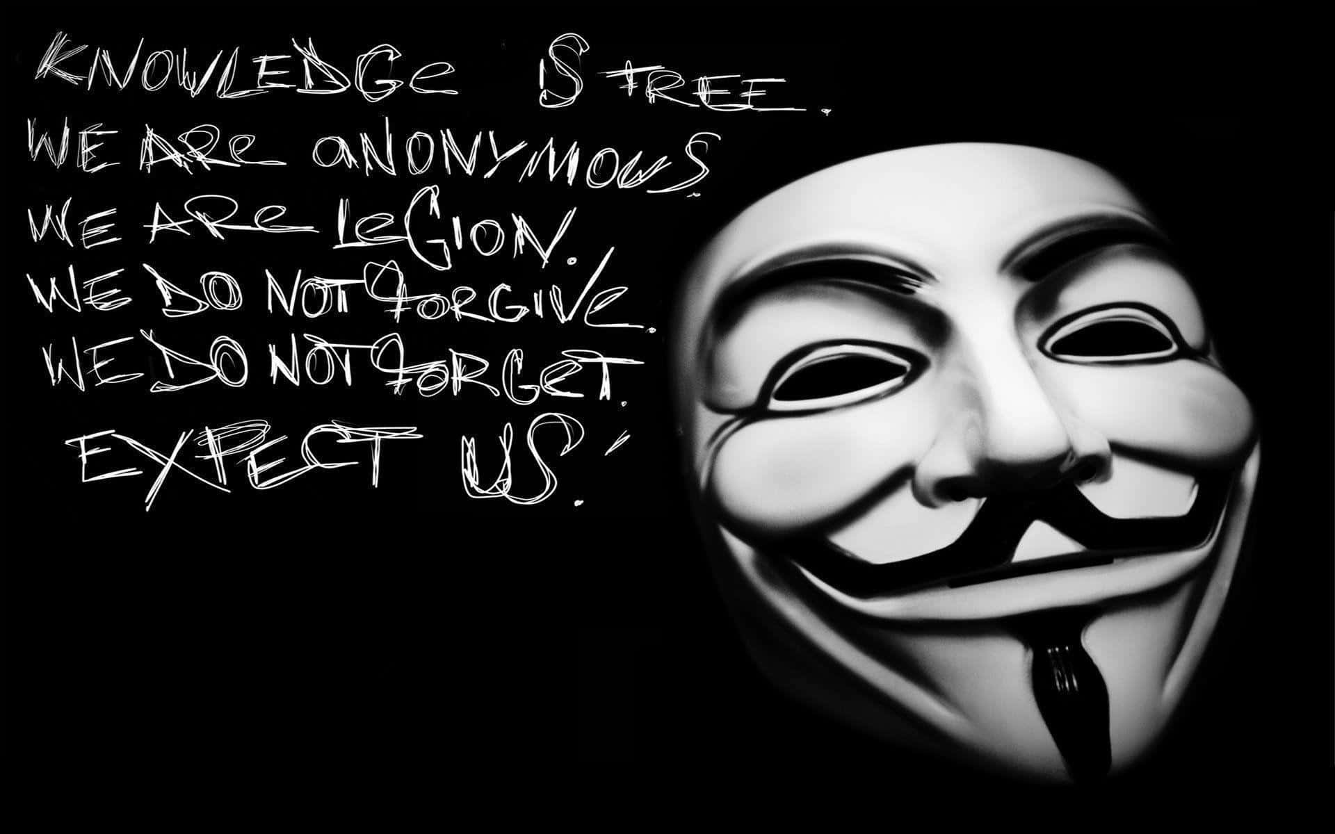 Anonymous 桌布 壁紙 — 一張鮮明的黑白圖片，描繪了蓋伊·福克斯面具，上面有粗體手寫抗議標語，背景為深色。
