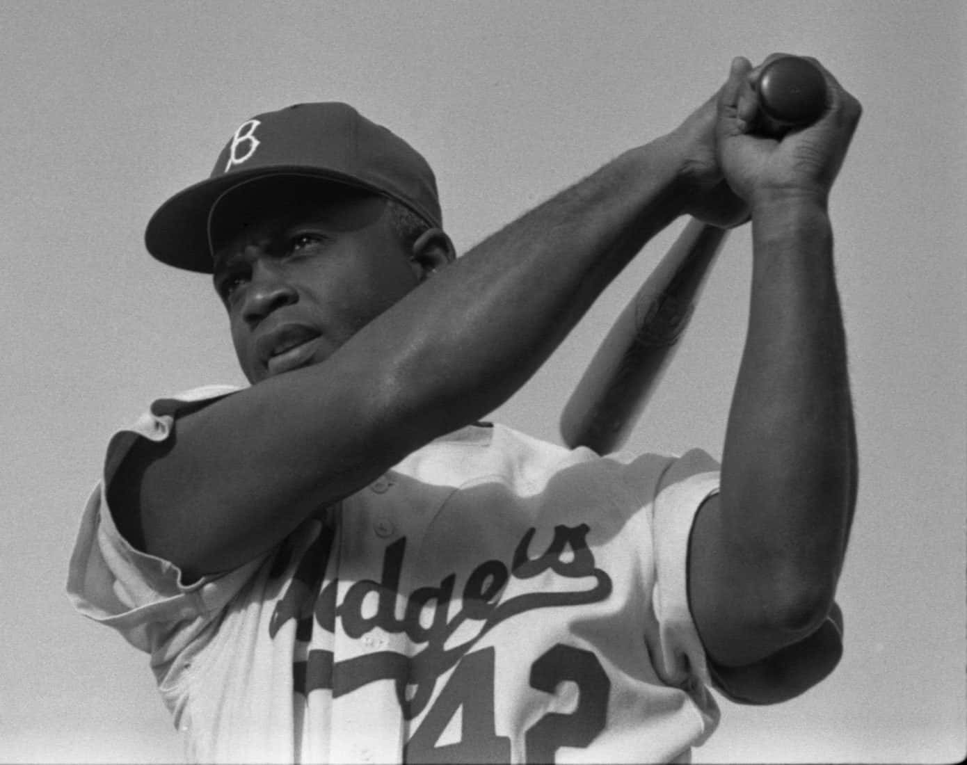 Jackie Robinson 桌布 壁紙 — 一張黑白低角度拍攝的道奇隊棒球選手，手持球棒擺出預備姿勢的照片。