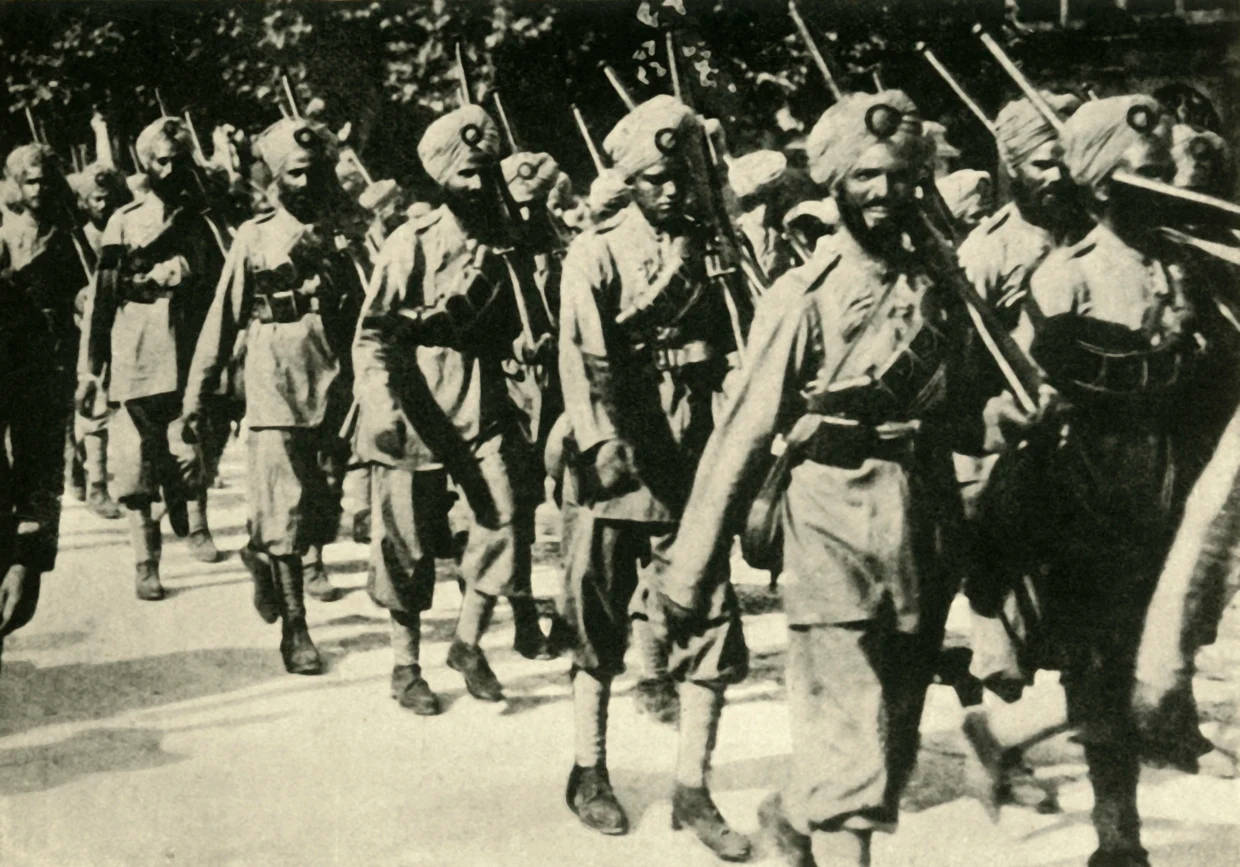 Indian Army 桌布 壁紙 — 一張黑白歷史照片顯示一排戴著頭巾的印度士兵，肩上掛著步槍，在綠樹成蔭的街道上行進。