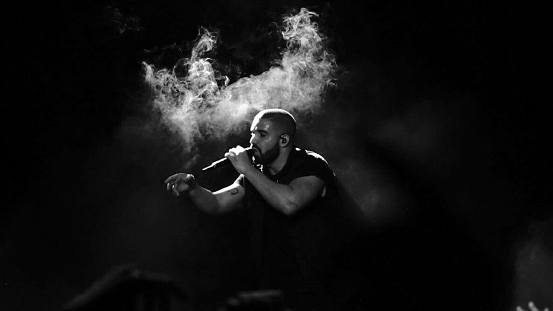 Drake 桌布 壁紙 — 一張黑白照片，一名禿頭男子對著麥克風唱歌，煙霧在他頭頂盤旋。