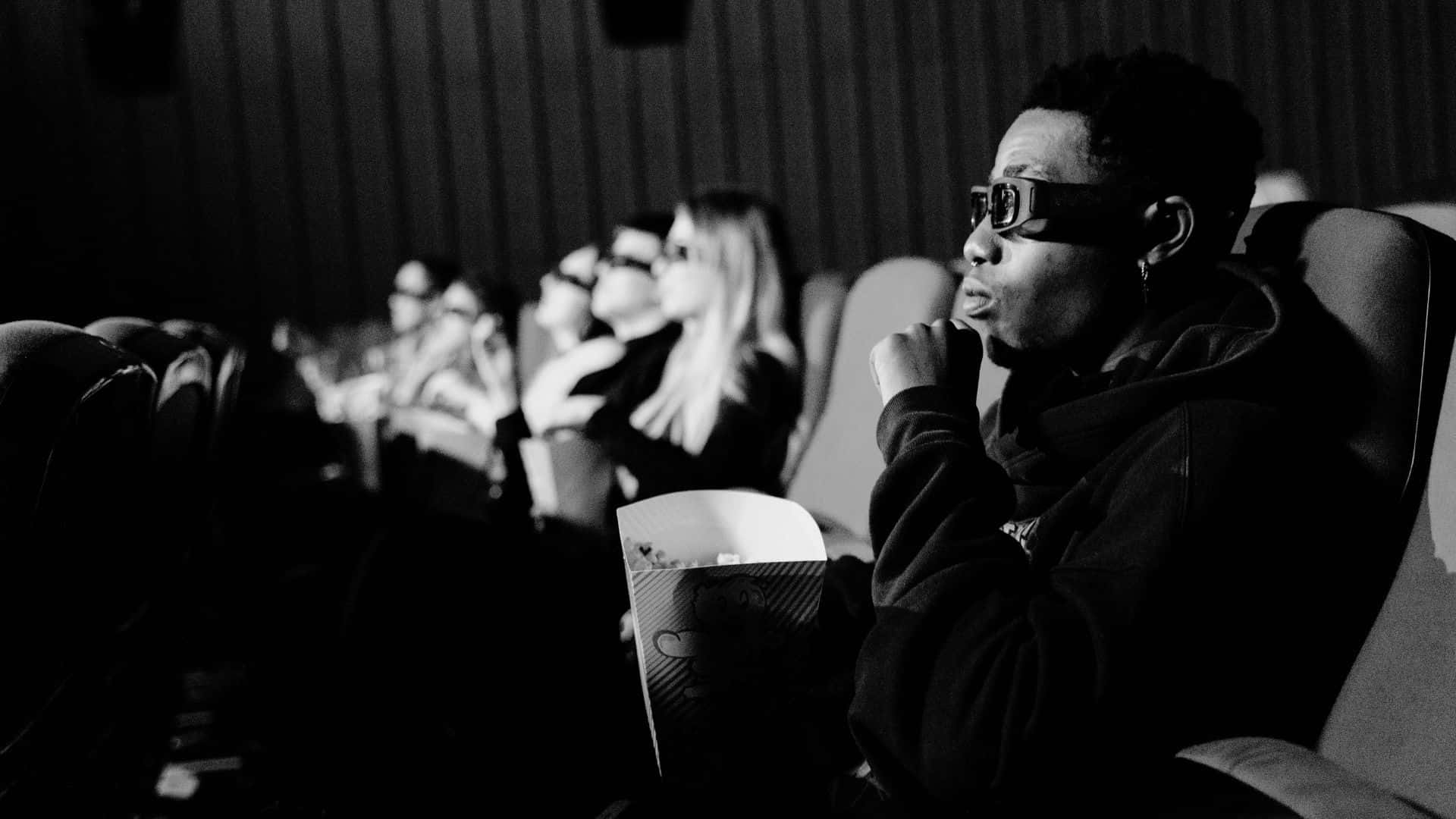 Black And White Movie 桌布 壁紙 — 一張黑白照片，人們在電影院戴著3D眼鏡吃爆谷。