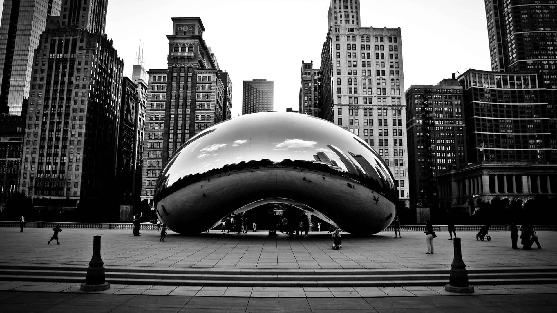 Black And White Architecture 桌布 壁紙 — 一張黑白照片，展示Cloud Gate雕塑反射摩天大樓和繁忙城市廣場上的人群。