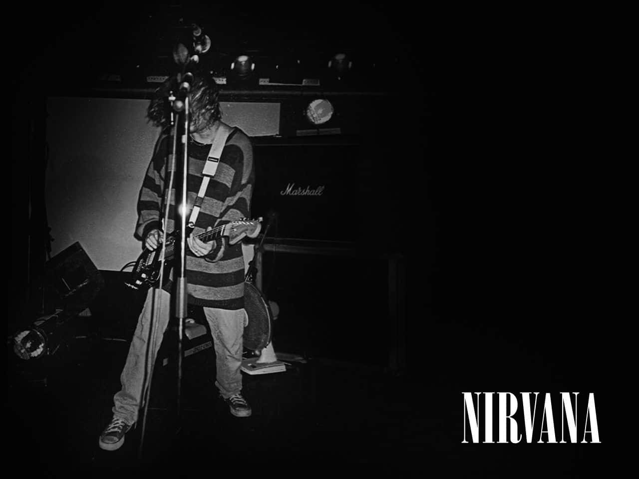 nirvana 桌布 壁紙 — 一張黑白照片，拍攝一位音樂家在舞台上彈結他，背景有Marshall擴音器。