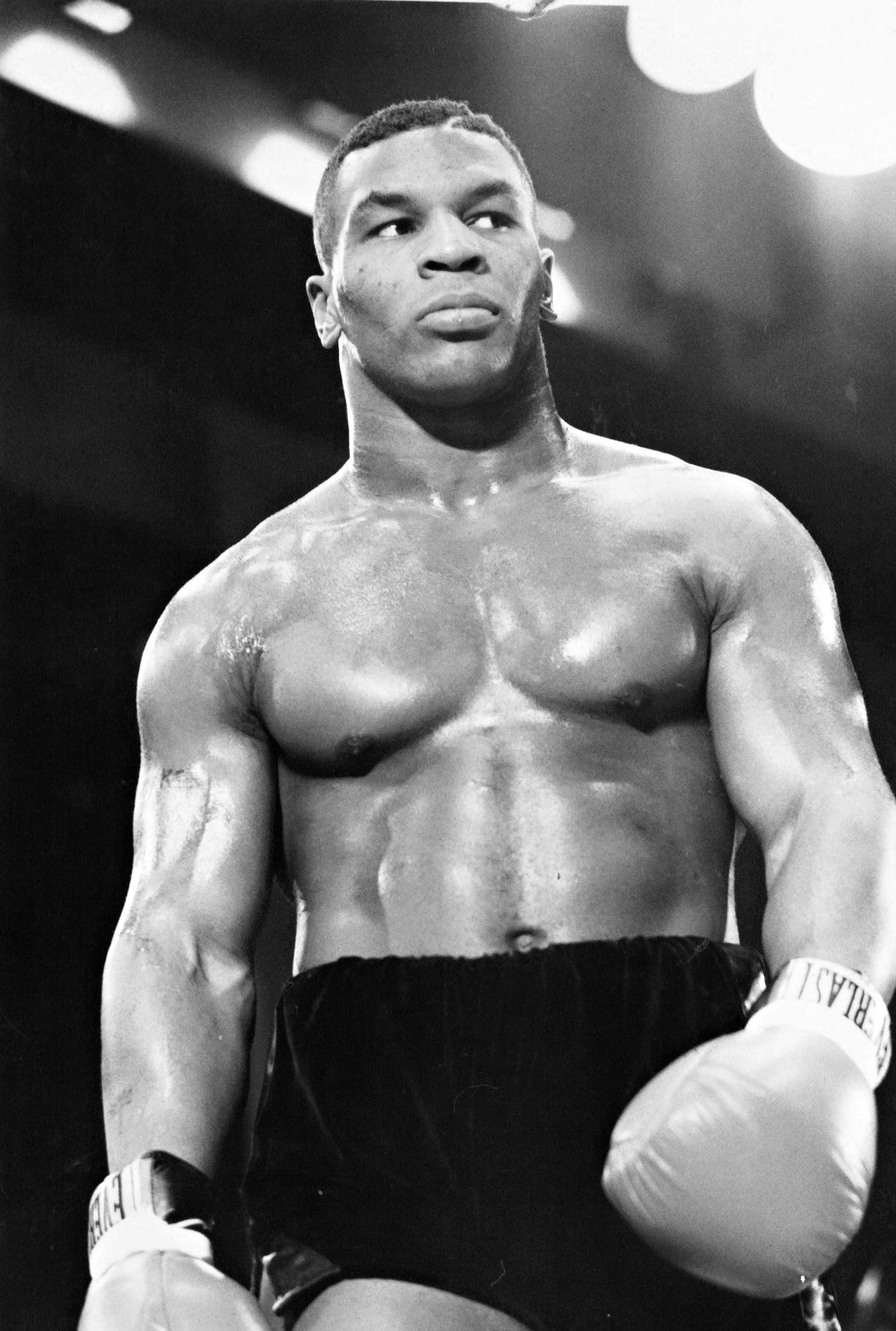 mike tyson 桌布 壁紙 — 一張黑白照片，拍攝一名肌肉發達的拳擊手在擂台上專注地向上望。
