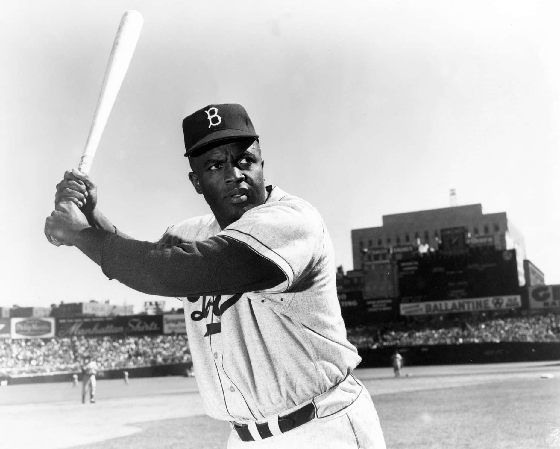 Jackie Robinson 桌布 壁紙 — 一張黑白照片，拍攝身穿波士頓勇士隊球衣的棒球手在球場中揮棒，背景有觀眾。