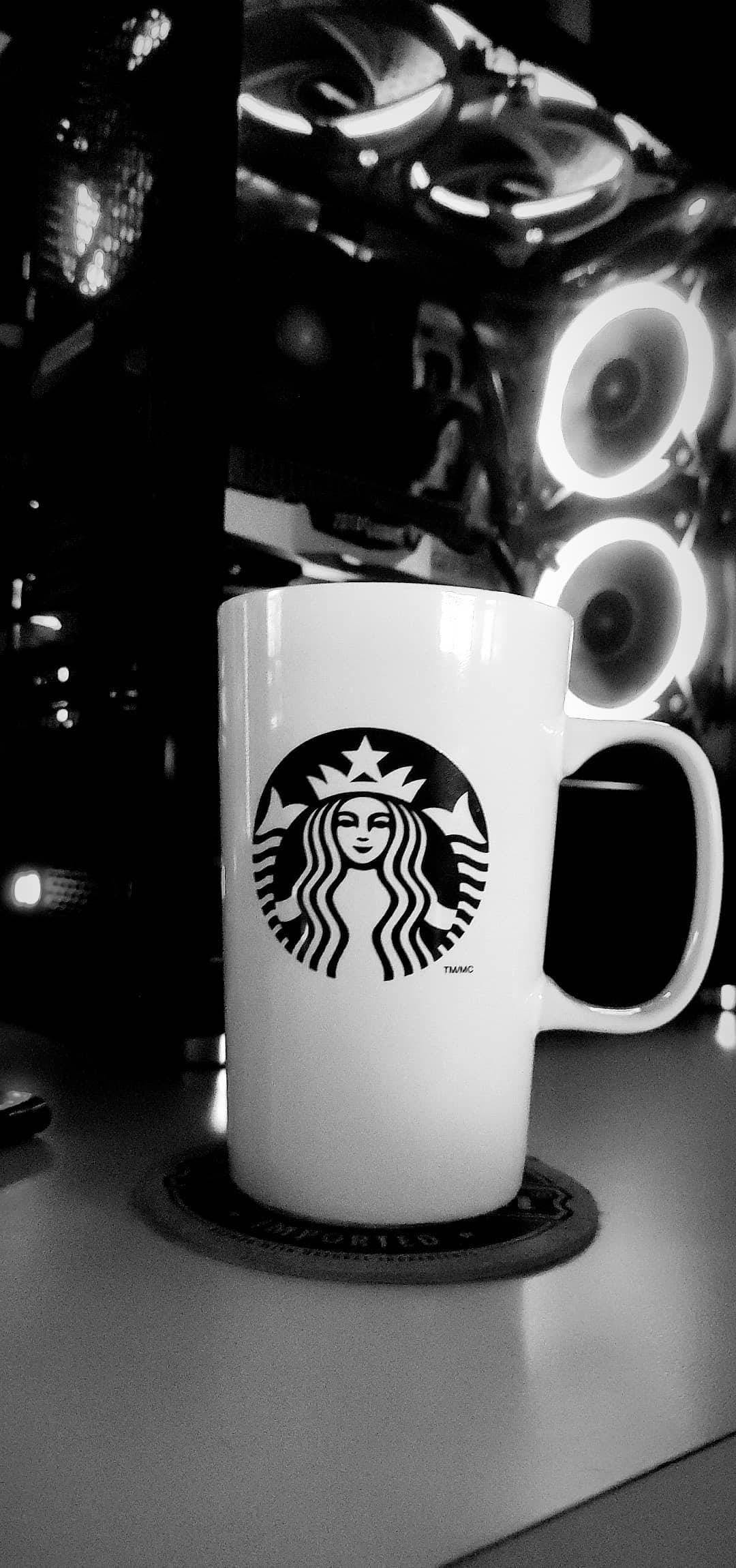 咖啡 桌布 壁紙 — 一張黑白照片，顯示一個Starbucks馬克杯放在杯墊上，前面是一個發光的電腦機箱。