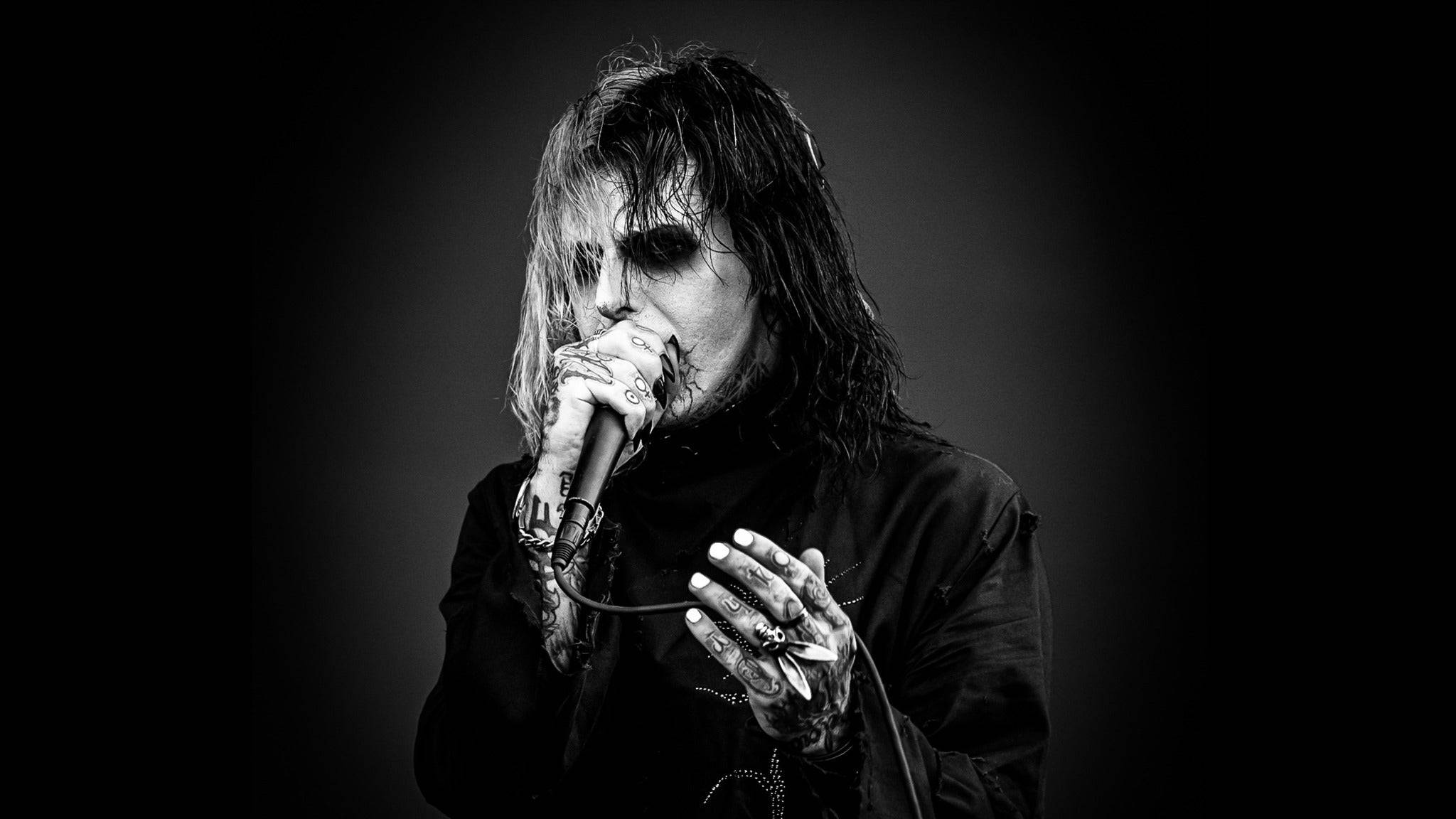 Ghostemane 桌布 壁紙 — 一張黑白肖像，描繪一位紋身音樂家，化著深色妝容，在漸變背景前對著麥克風唱歌。