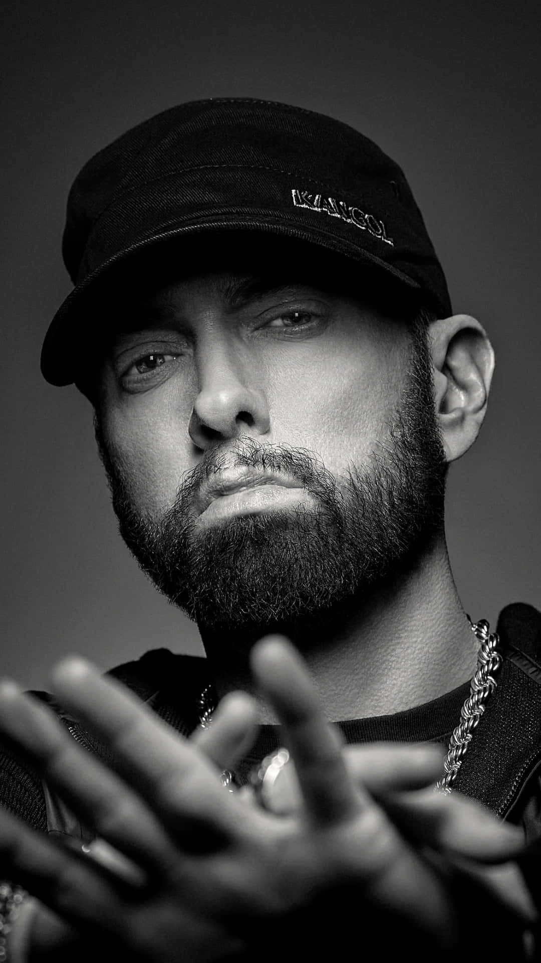 Eminem 桌布 壁紙 — 一張黑白肖像照，一名留鬍鬚的男子戴著帽子和鏈條，雙手向前比劃。