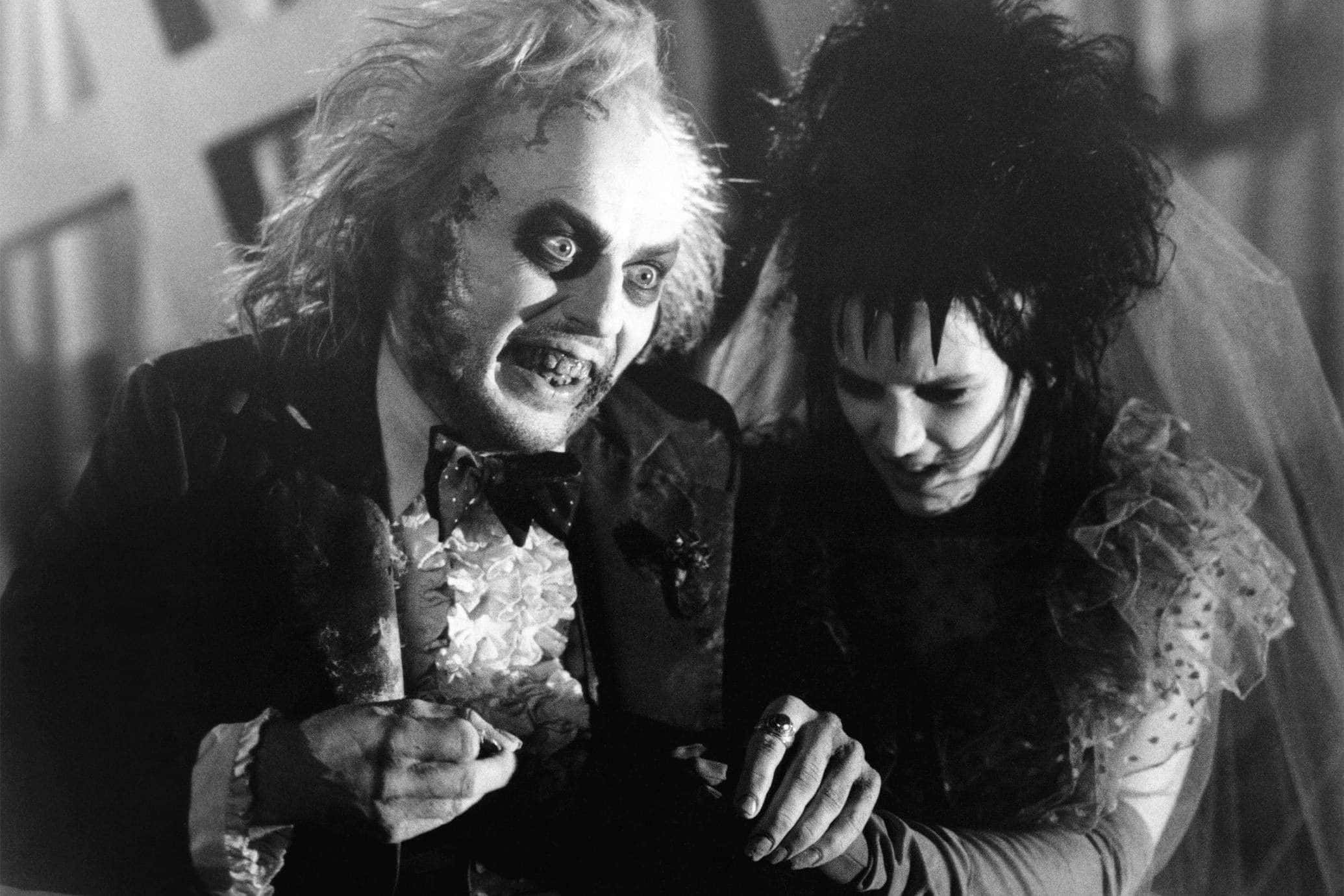 嘩鬼家族 桌布 壁紙 — 一張黑白電影劇照顯示了Beetlejuice和一位身穿哥德式婚紗的新娘，妝容誇張，頭髮狂野。