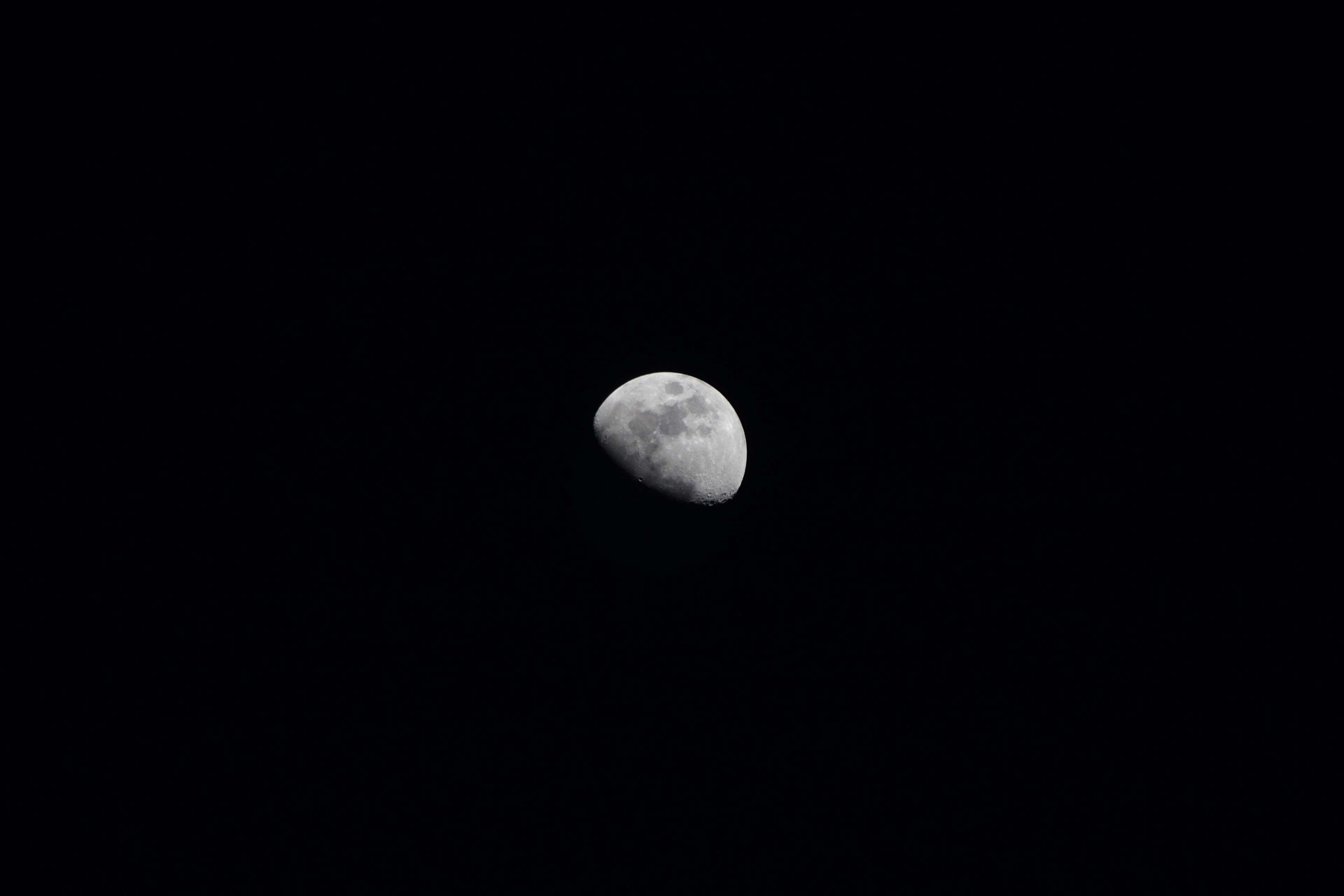 Moon Phases 桌布 壁紙 — 一彎明亮的月牙在沒有星星的深黑夜空下柔和地發光。