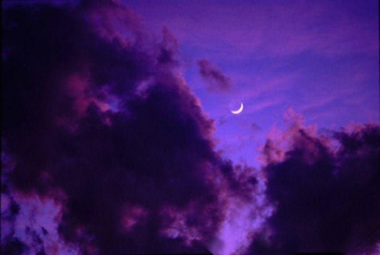 天空 桌布 壁紙 — 一彎精緻的月牙在充滿紋理雲層的戲劇性紫色天空中柔和發光。