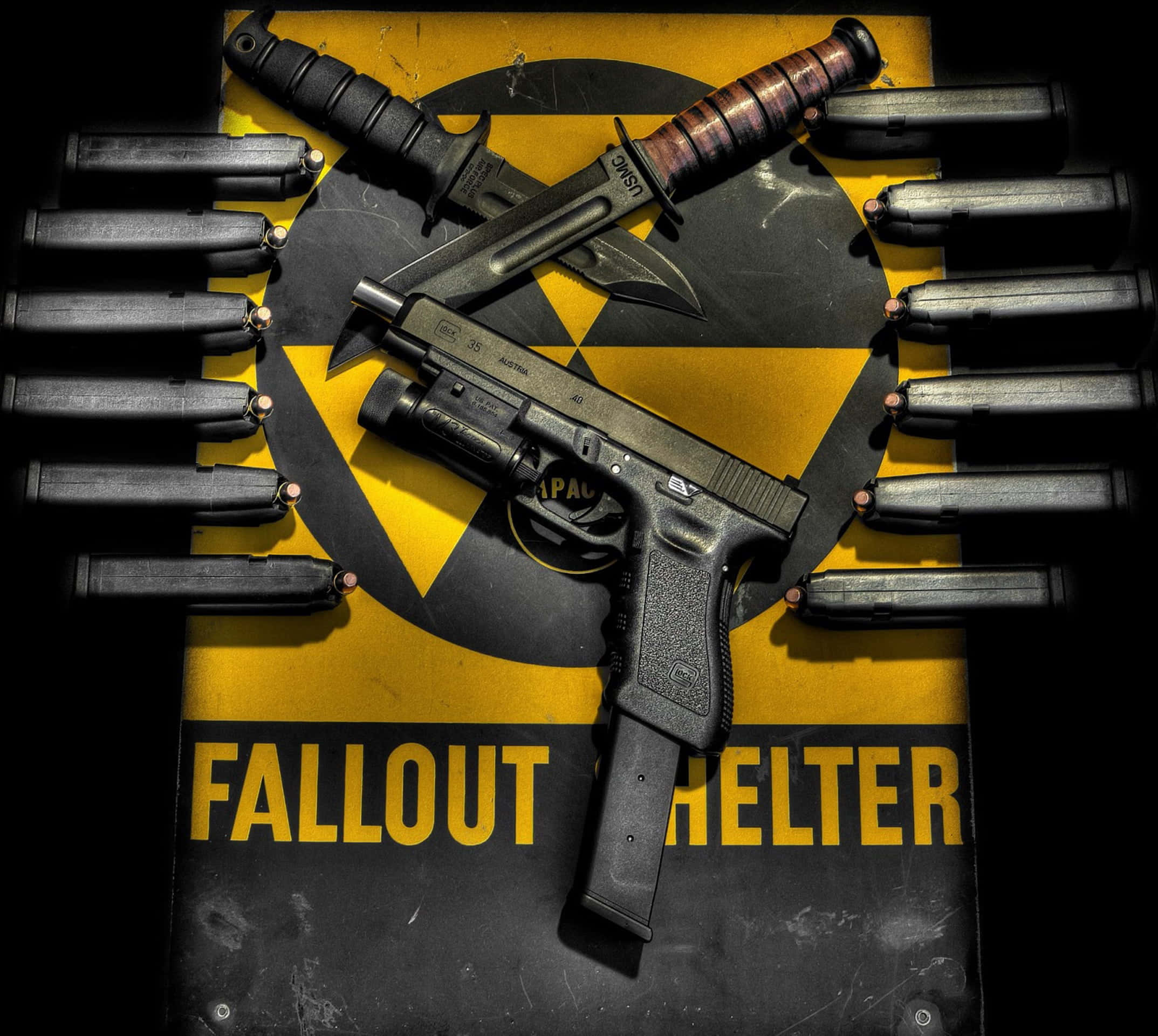 Fallout Shelter 桌布 壁紙 — 一把手槍和兩把刀放在一個風化的輻射避難所標誌上，周圍環繞著彈藥。