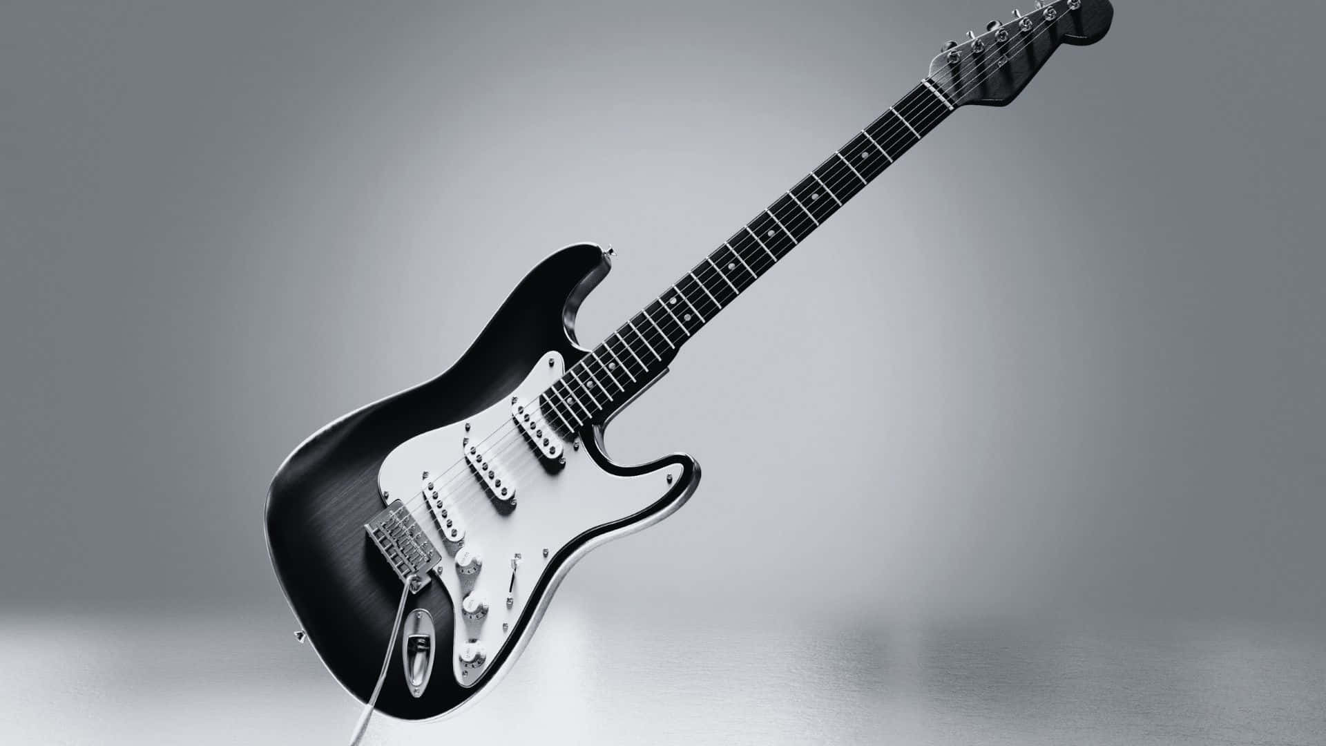 Black And White Guitar 桌布 壁紙 — 一把時尚的黑色電結他配白色護板，在柔和的灰色漸變背景上對角懸浮。