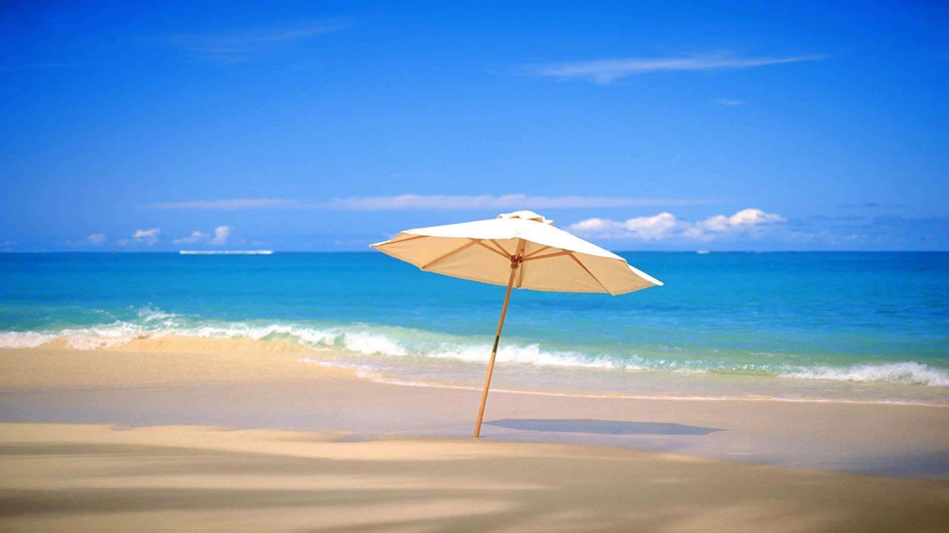 Beautiful Beach 桌布 壁紙 — 一把米色沙灘傘獨自立在金色沙灘上，碧綠色的海浪在清澈的藍天下翻滾。