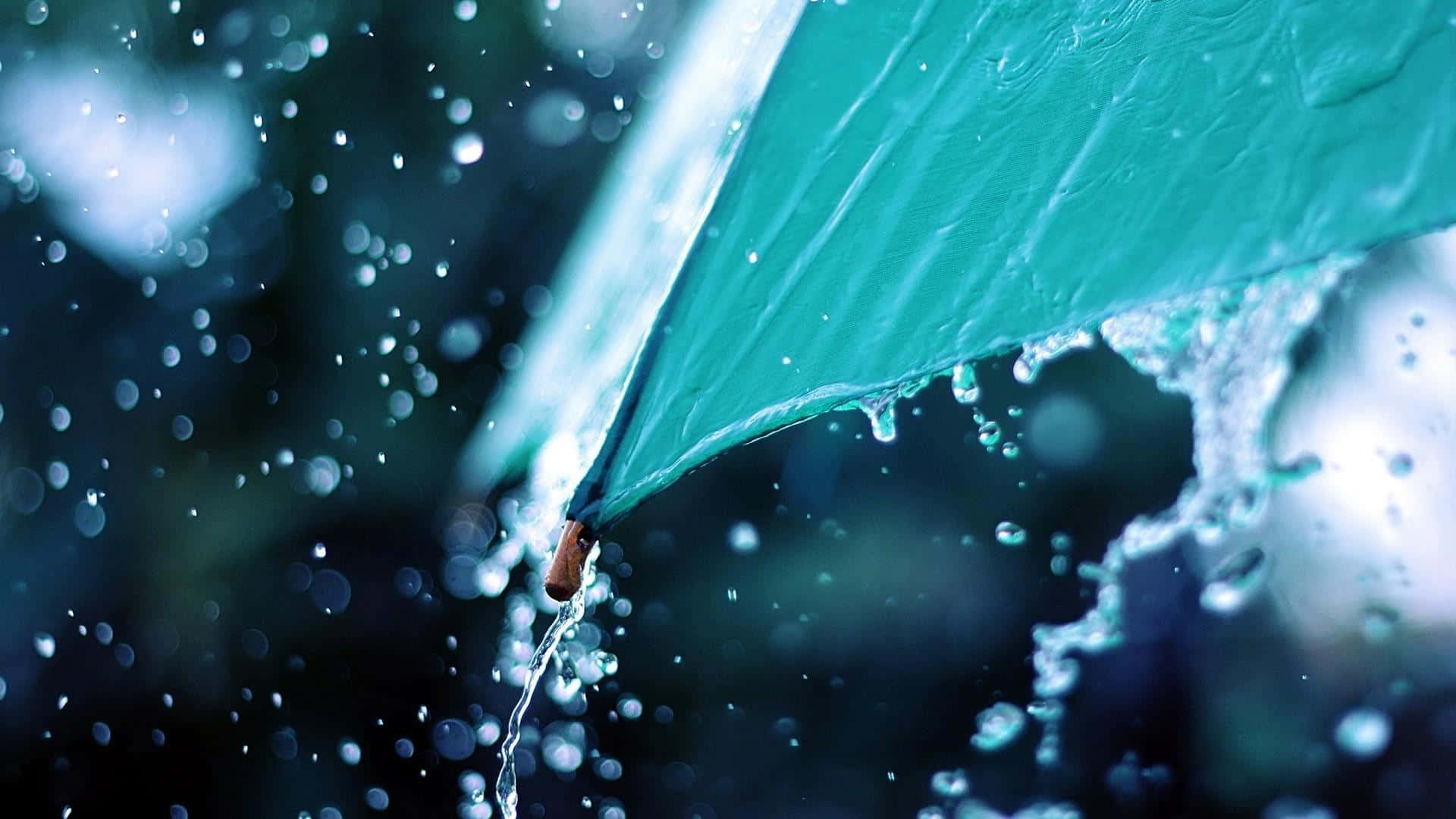 落雨 桌布 壁紙 — 一把青綠色雨傘在雨中場景滴下水珠，閃爍的水滴和模糊的黑暗背景。