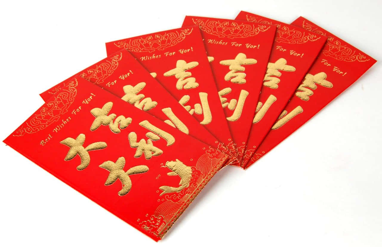 Red Envelope 桌布 壁紙 — 一把鮮紅色信封扇，上面有金色漢字和魚圖案，象徵繁榮和好運。