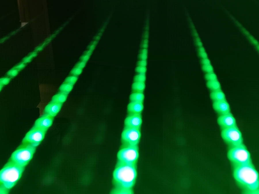 桌布 壁紙 — 一排排發光的綠色LED燈消失在黑暗中，營造出未來感的隧道效果。