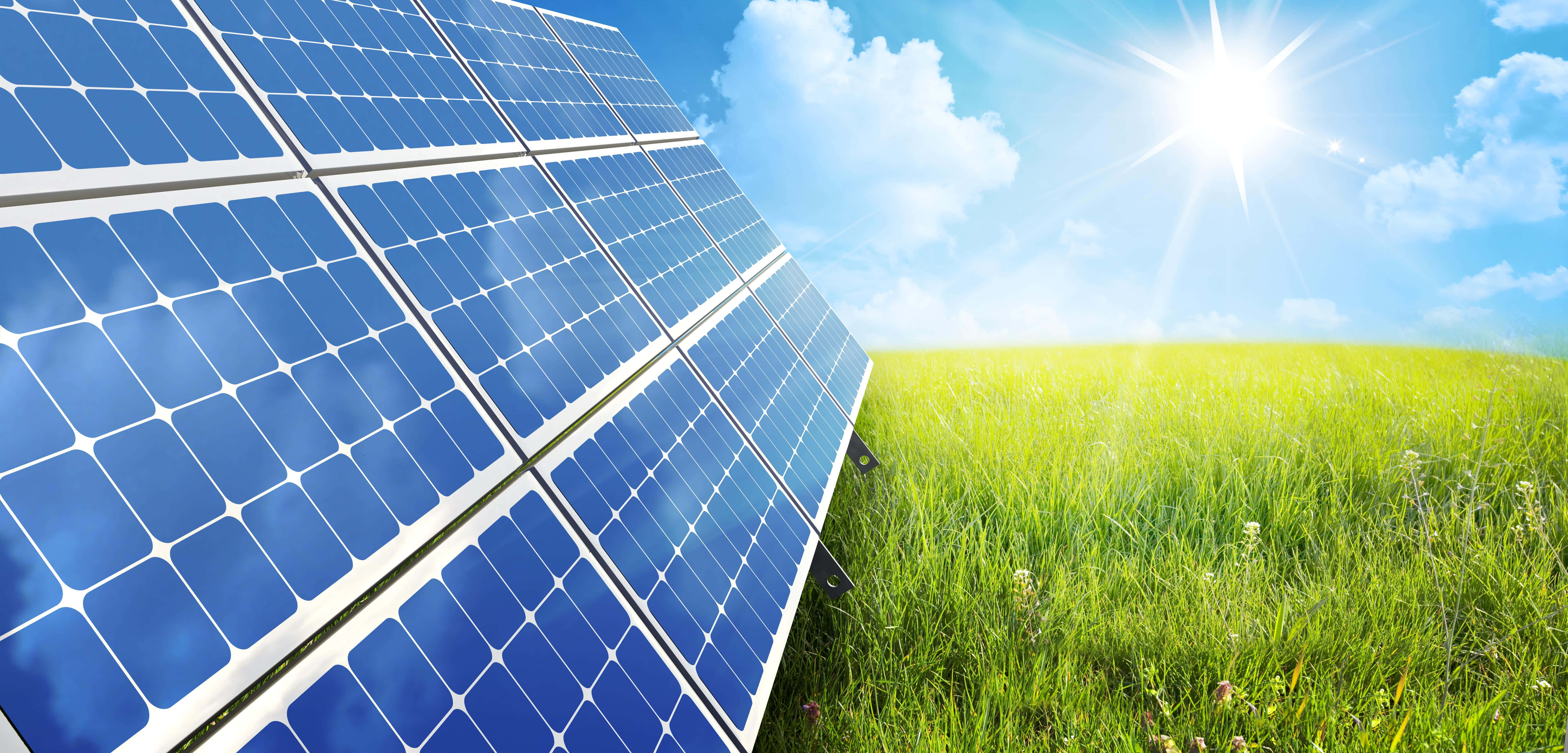 Energy 桌布 壁紙 — 一排排藍色太陽能板在明媚陽光下閃閃發光，位於一片茂盛的綠色田野上，天空中有蓬鬆的白雲。