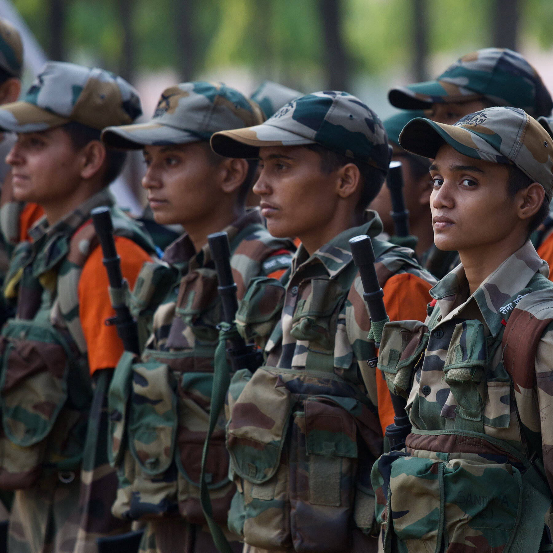 Indian Army 桌布 壁紙 — 一排身穿迷彩服的年輕士兵在戶外持槍立正，專注而有紀律。