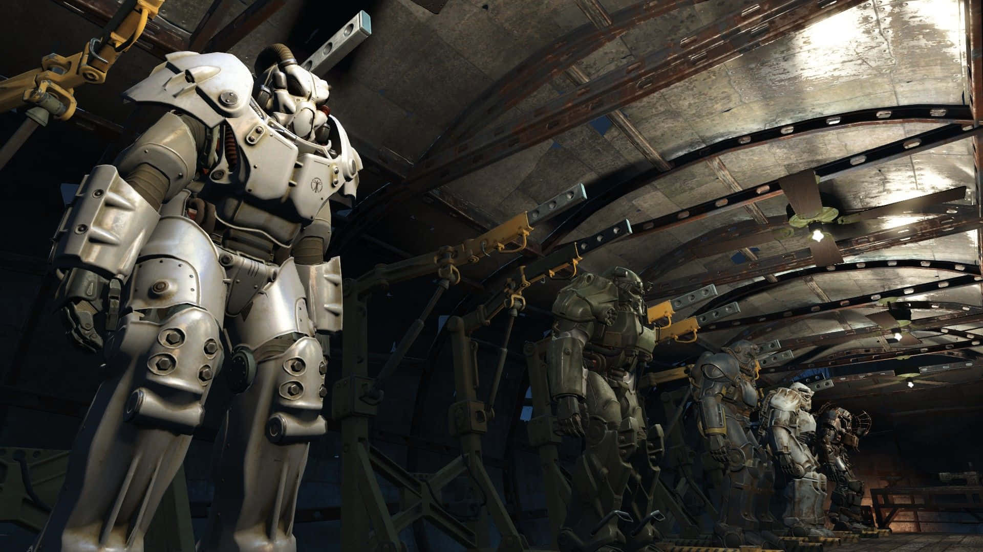 Fallout 4 Power Armor 桌布 壁紙 — 一排重型裝甲動力裝甲服站在一個光線昏暗的工業機庫中，有暴露的管道和金屬橫樑。