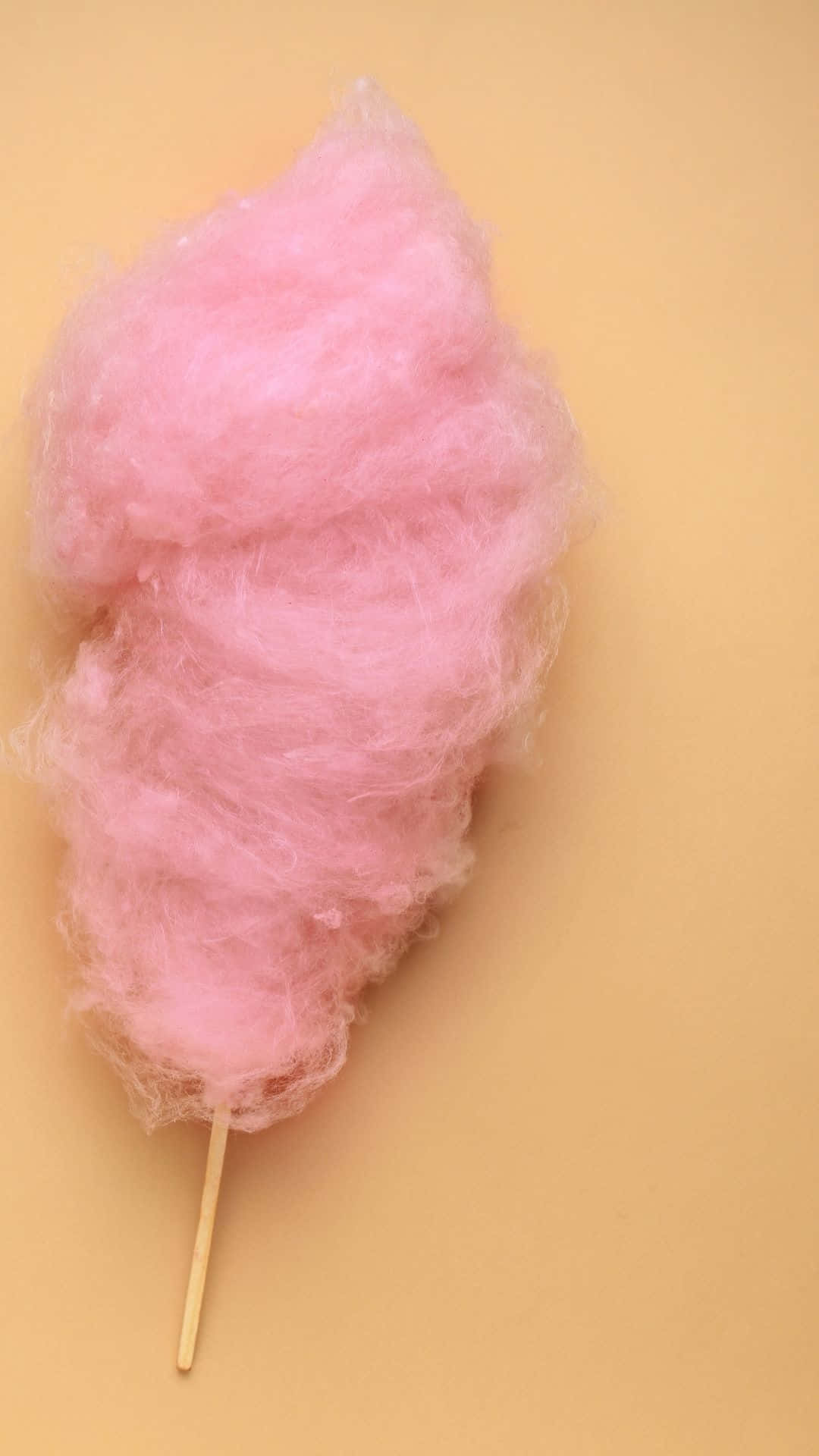 Cotton Candy 桌布 壁紙 — 一支粉紅色 fluffy 棉花糖旋轉在溫暖的米色背景上。
