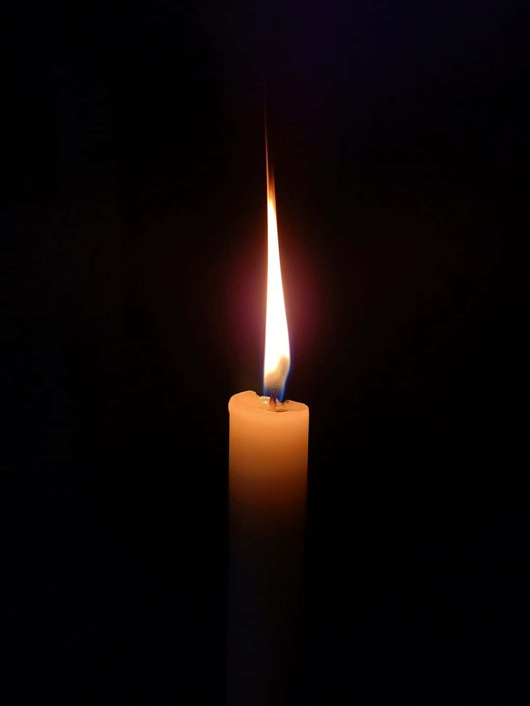 Rip 桌布 壁紙 — 一支點燃的蠟燭在漆黑的背景下散發出溫暖的光芒，營造出寧靜而親密的氛圍。