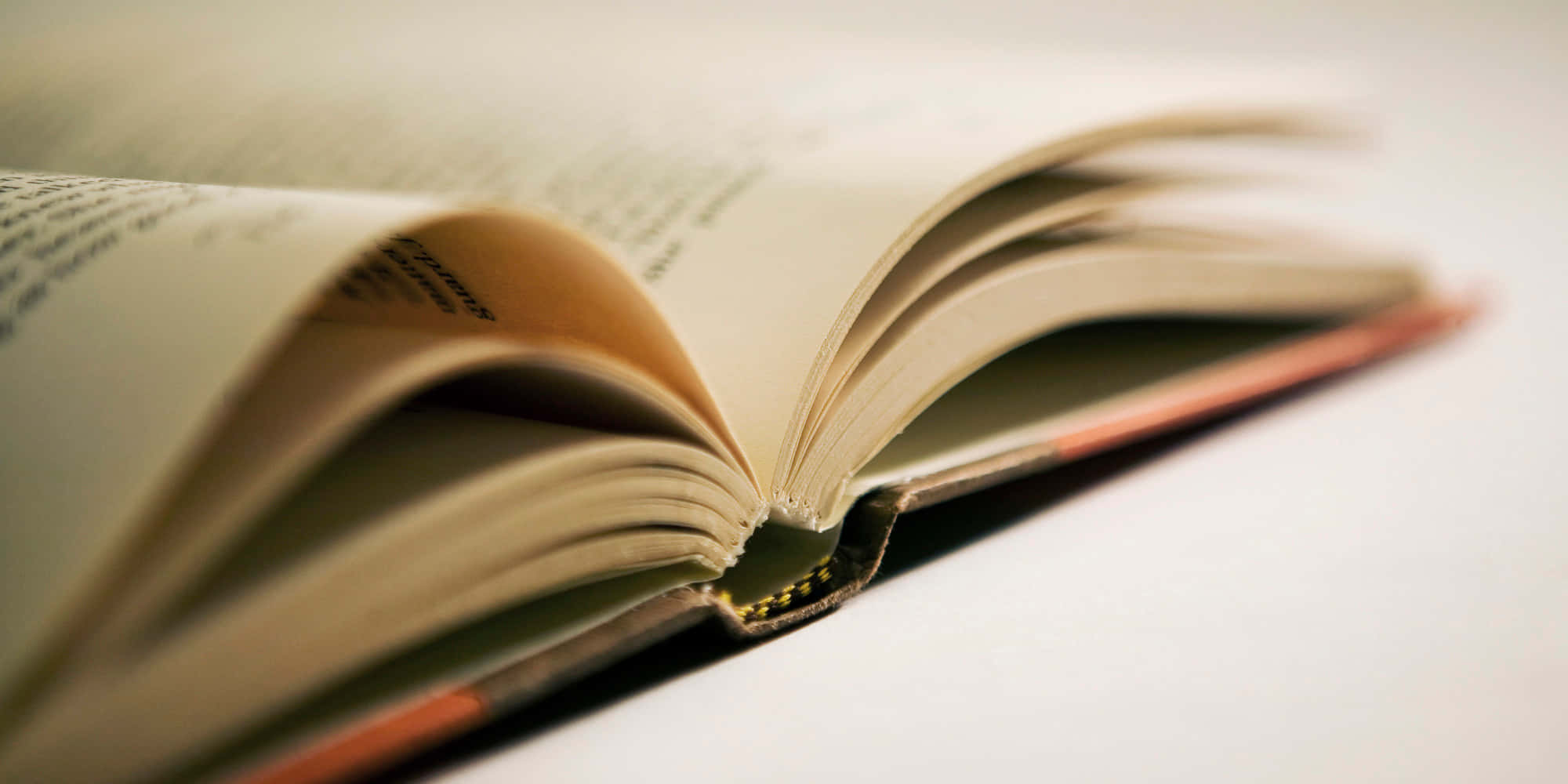一本打開的書，上面有一片金箔 壁紙