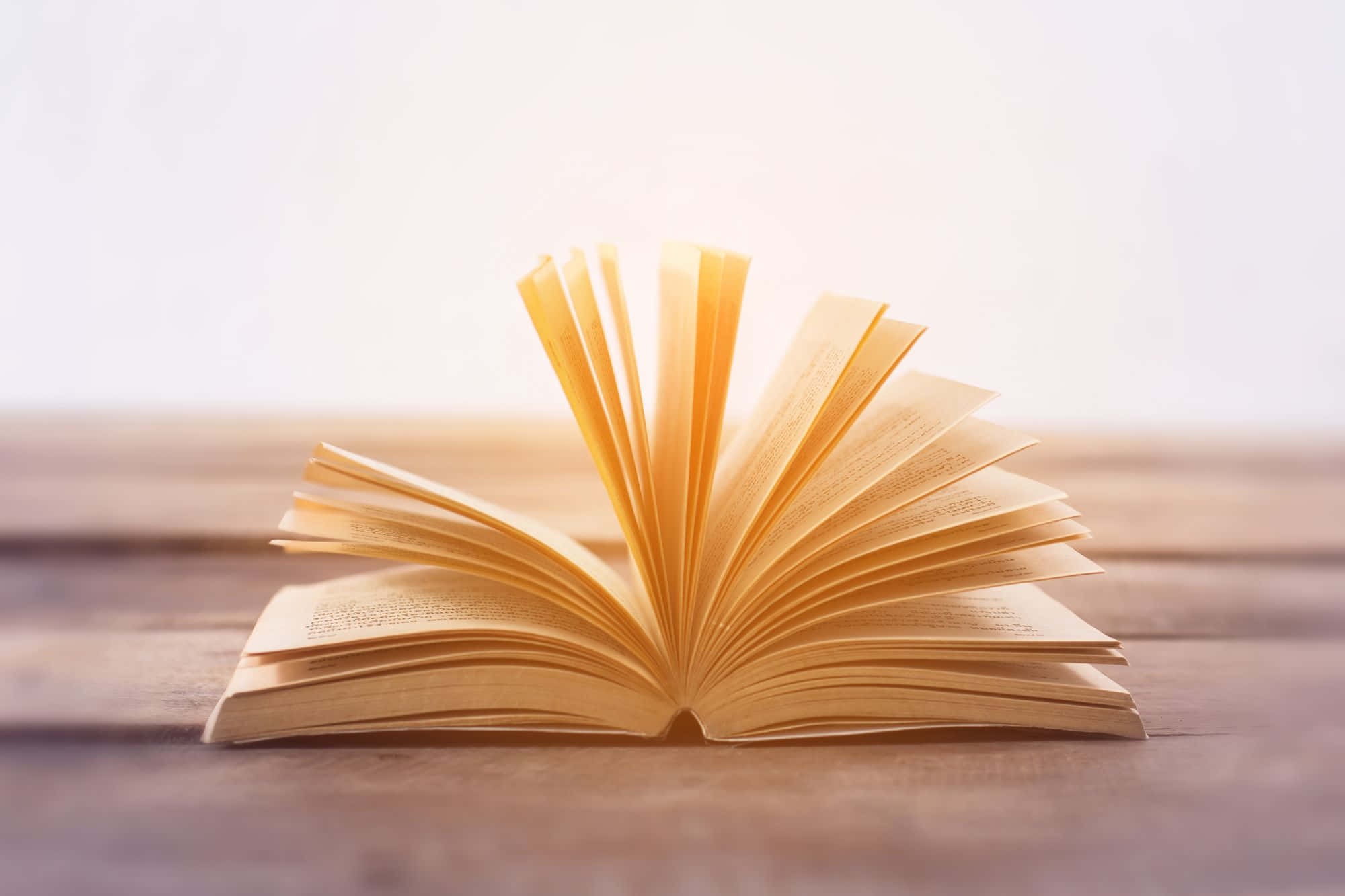 一本打開的書放在木桌上 壁紙