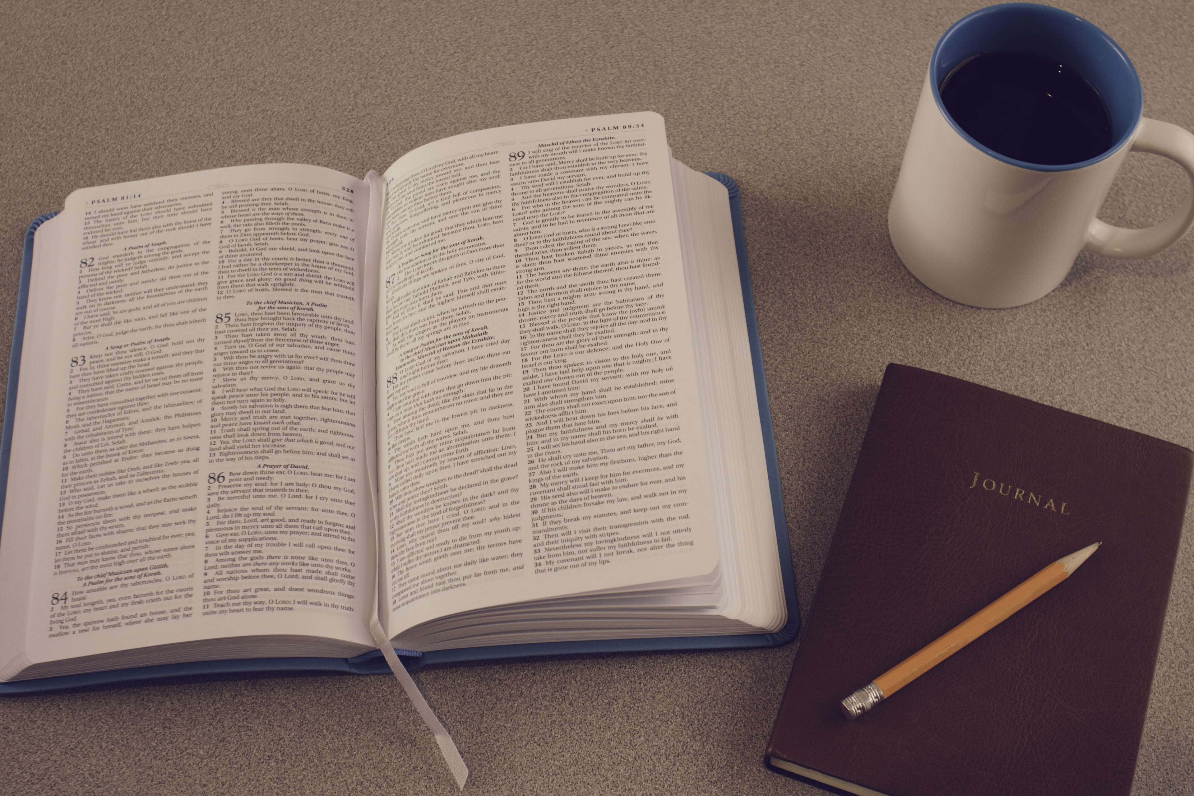 Bible Study 桌布 壁紙 — 一本打開的藍色封面聖經放在一個中性色調的檯面上，旁邊有一個藍色馬克杯和一本附有鉛筆的日記本。