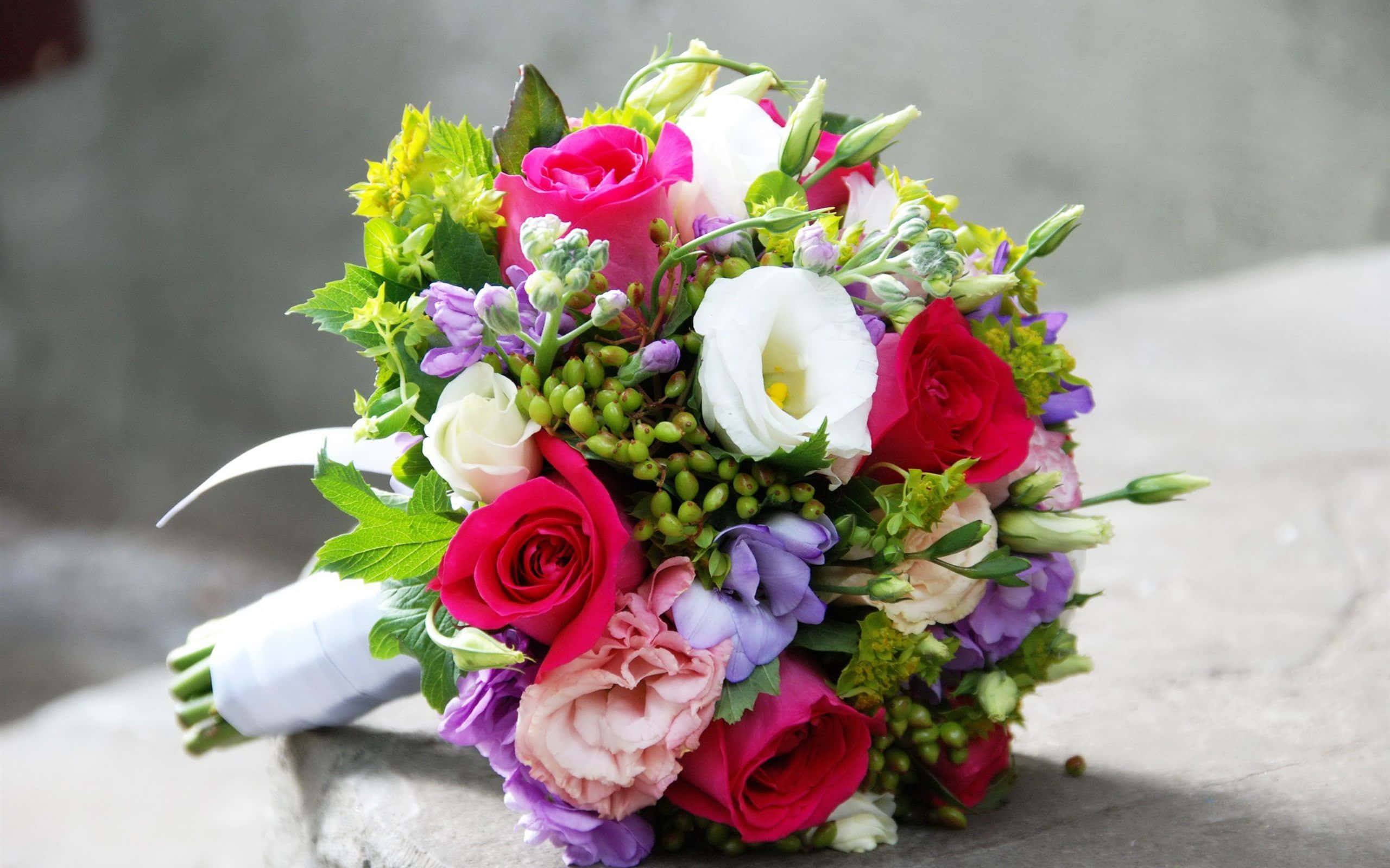 Floral Arrangement 桌布 壁紙 — 一束充滿活力的婚禮花束，包含粉紅、紅、白玫瑰、薰衣草和綠葉，放置在石面上。