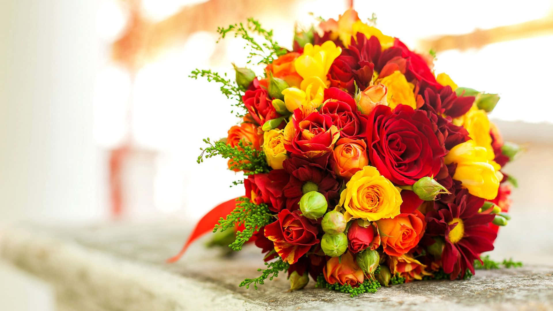 Flower Arrangement 桌布 壁紙 — 一束由紅、黃、橙色玫瑰和大麗花組成的鮮豔花束放在石面上，柔和陽光穿透而過。