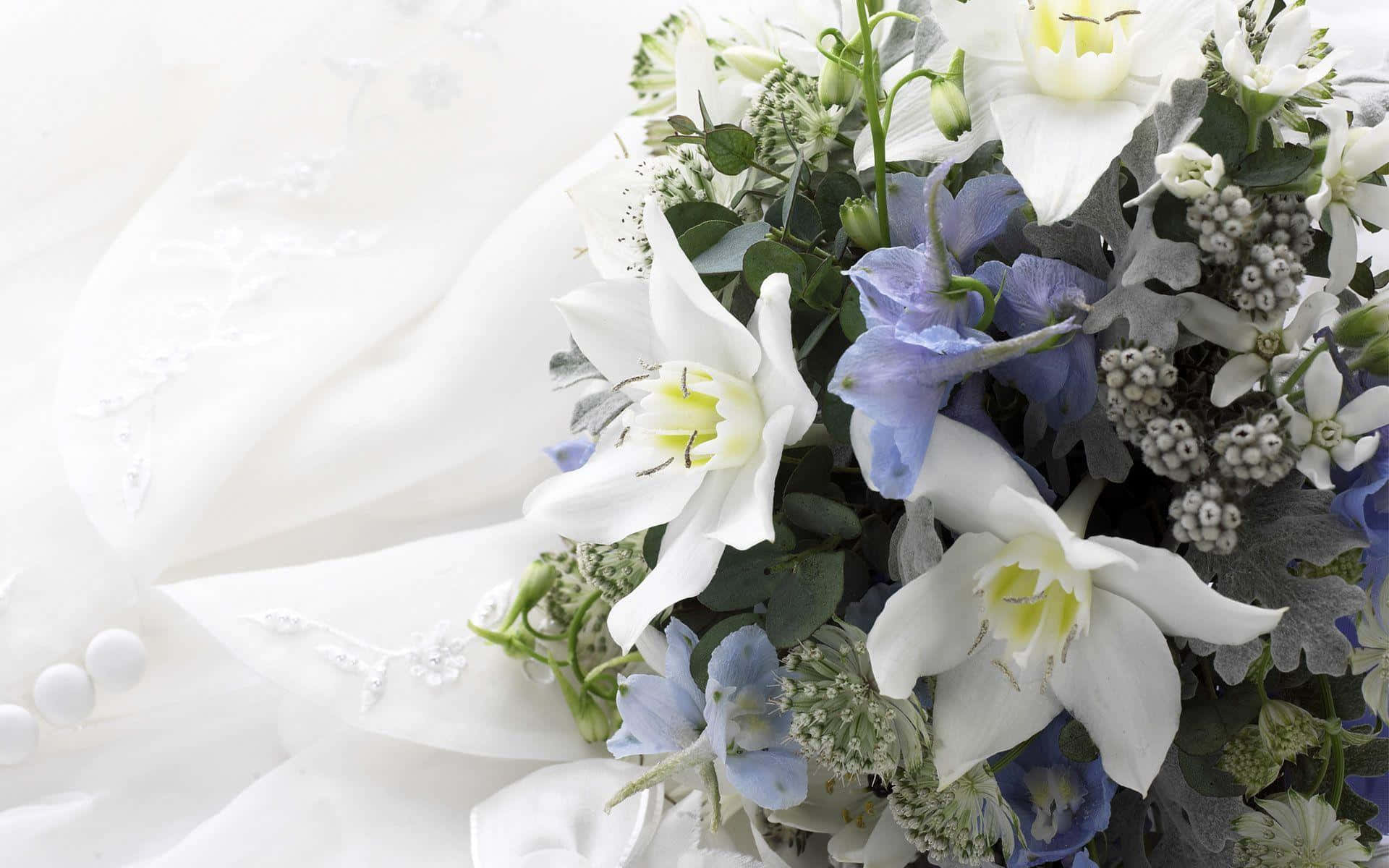 Wedding Flowers 桌布 壁紙 — 一束精緻的白藍色花束放在一件帶有珍珠鈕扣的紋理白色婚紗旁邊。