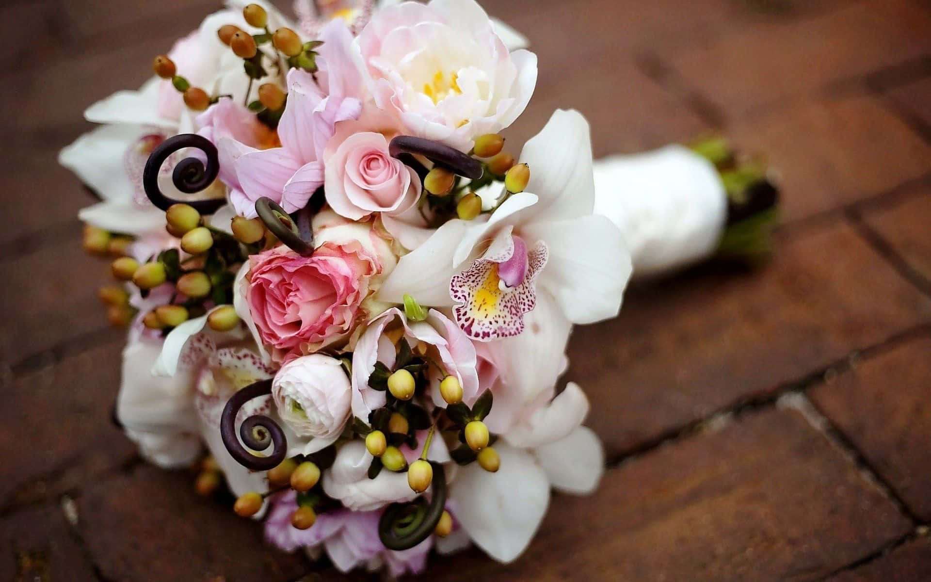 Wedding Flowers 桌布 壁紙 — 一束精緻的粉紅玫瑰、白色蘭花和黃色漿果放在質樸的磚面上。