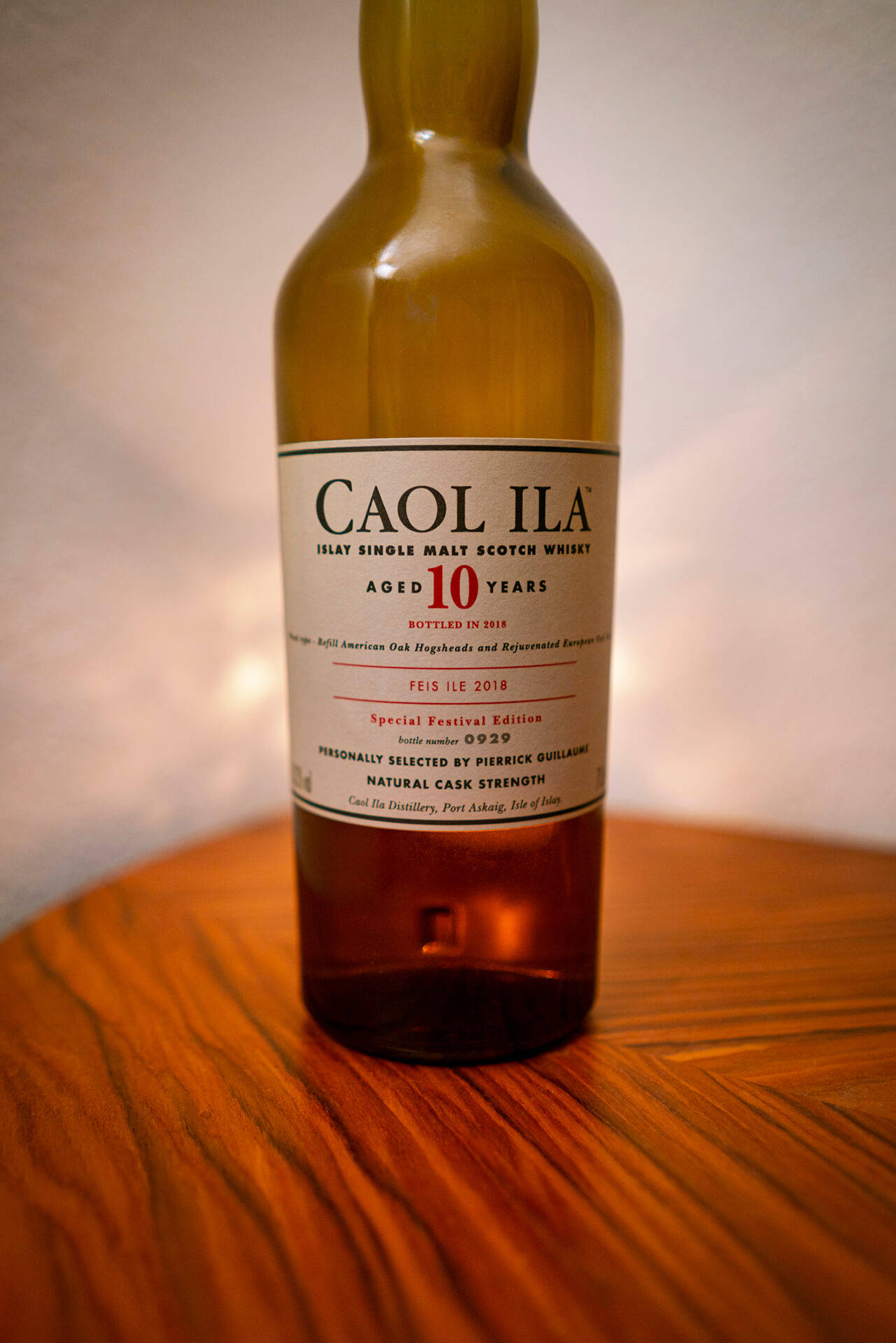 一瓶 Caol Ila 10 年威士忌放在木桌上。