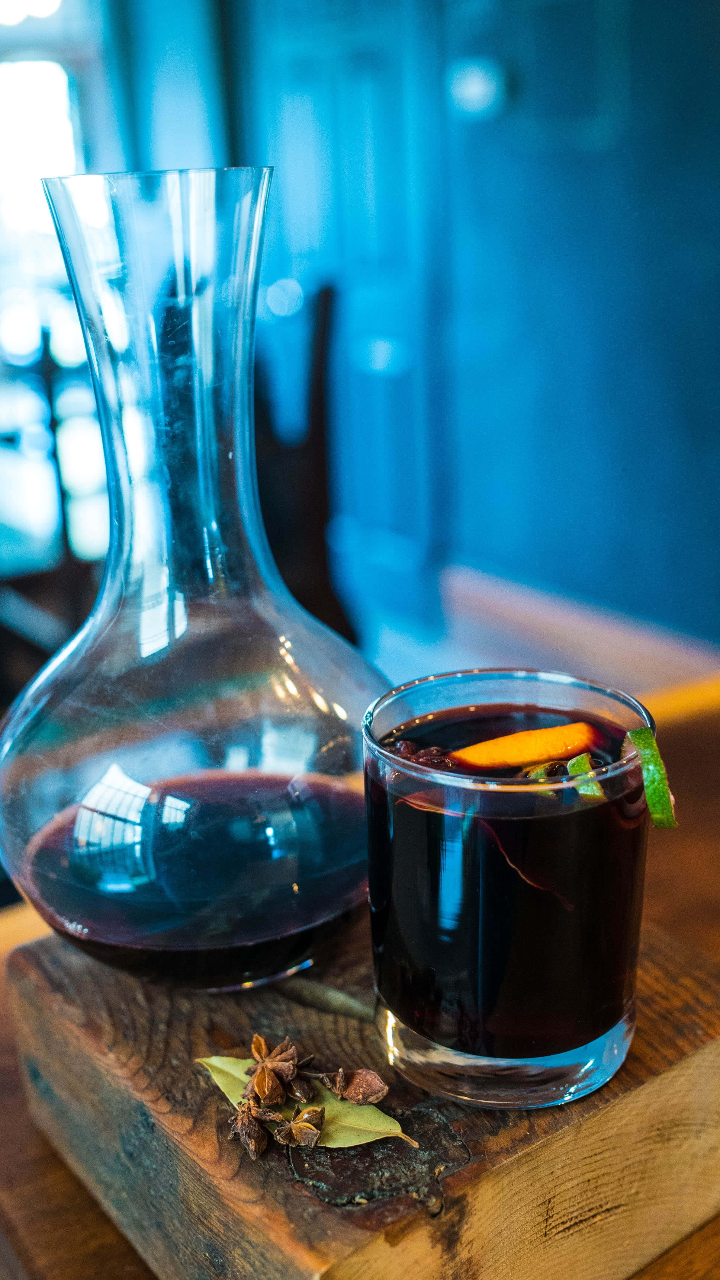 Mulled Wine 桌布 壁紙 — 一杯加了香料嘅熱紅酒，配上橙片同薄荷裝飾，放喺一個鄉村風格嘅木板上，旁邊仲有一個玻璃瓶。