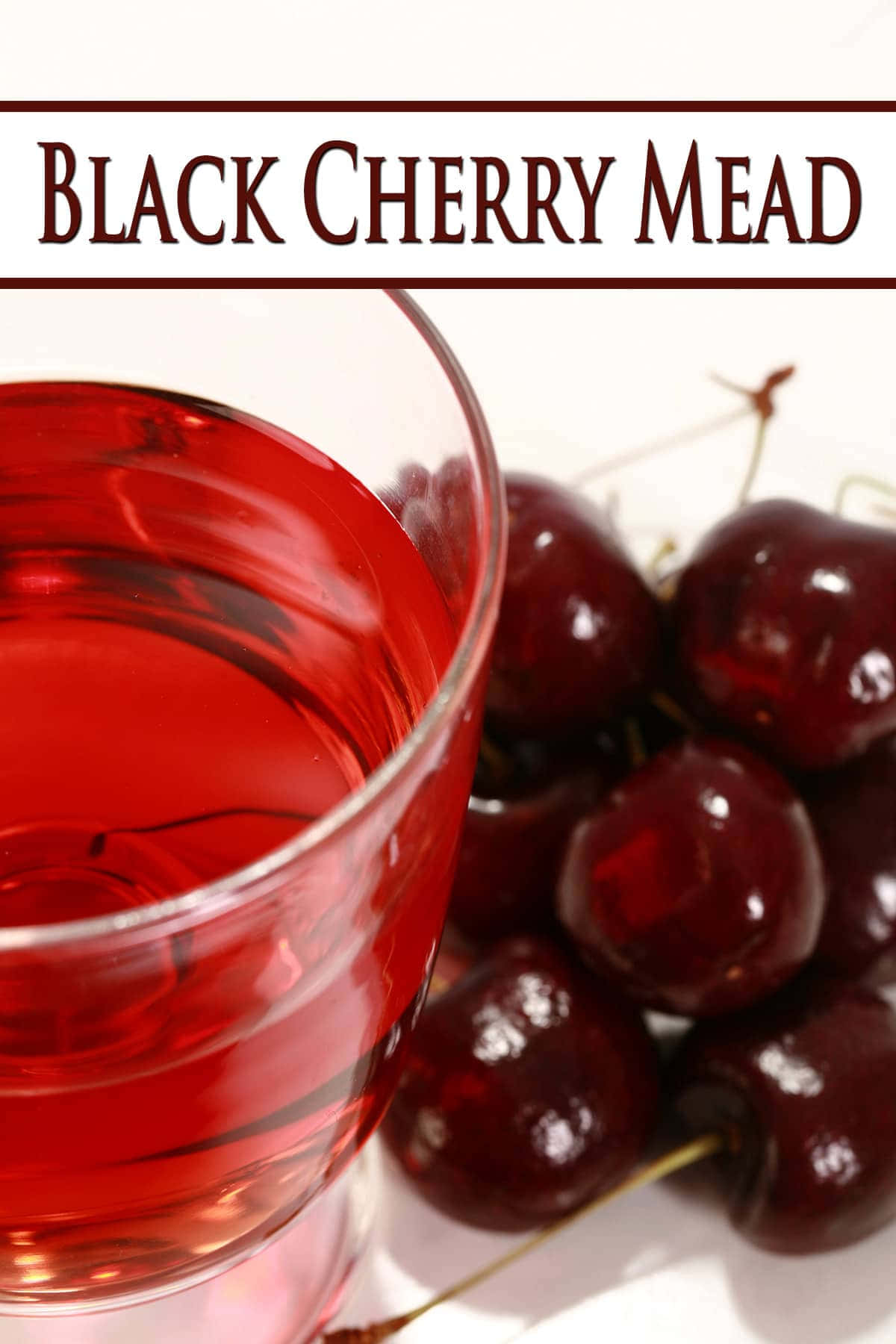 Black Cherry 桌布 壁紙 — 一杯濃郁的紅黑櫻桃蜂蜜酒放在白色表面上，旁邊是光澤的深色櫻桃。